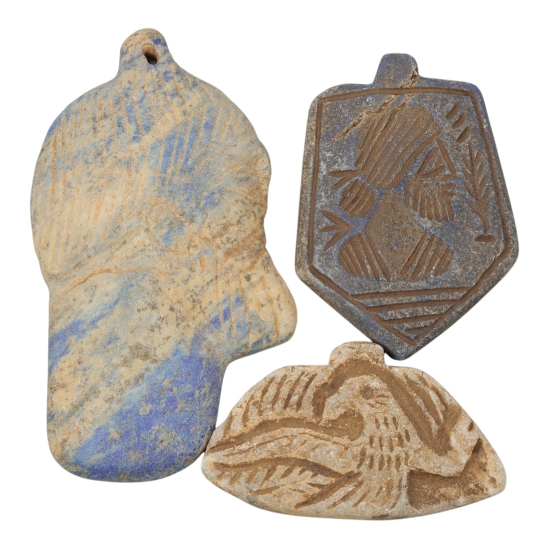 Lot of 3 Ancient Near Eastern Lapis Lazuli and Stone Amulets, Circa Iron Age, 6AE: The group comprises three amulets, including two lapis lazuli examples and one stone example, each with a suspension loop for wear. The first is a large hand-shaped lapis lazuli amulet, with incised p