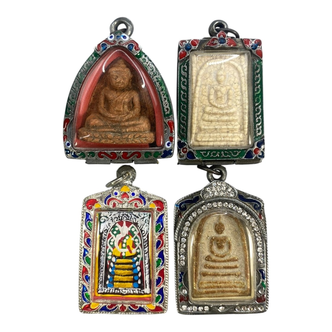A Lot of 4 Vintage Thai Buddhist Amulets with Enamel and Jewel Accents, 12WS: A curated lot of four vintage Thai Buddhist amulets, each encased in decorative metal frames with enamel detailing and jewel accents. The amulets depict traditional seated Buddha iconography, with var
