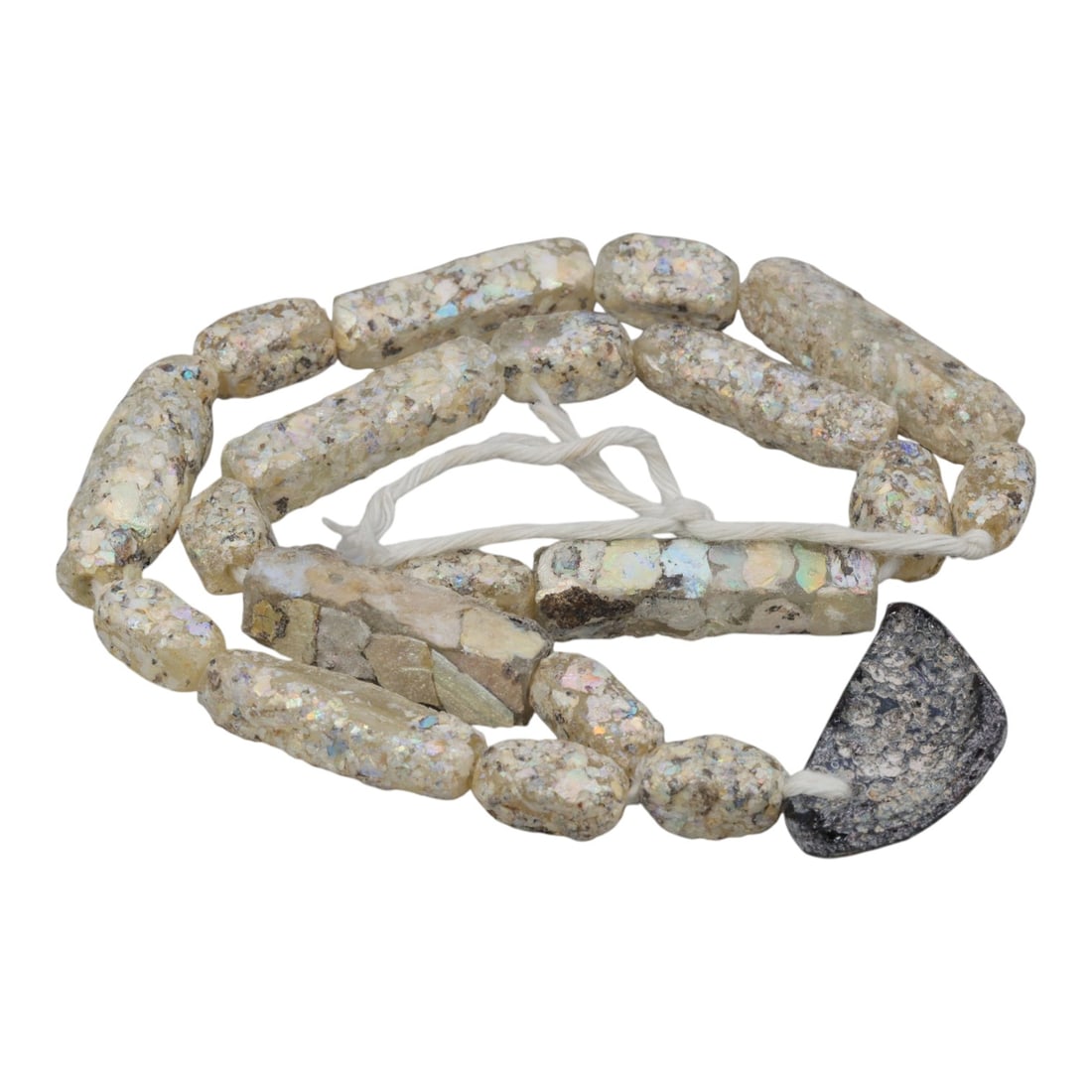 Ancient Roman Glass Beads with Pendant, Unstrung, 23AH: A single strand of unstrung ancient Roman glass beads, measuring approximately 22 cm in length. The strand features irregularly shaped cylindrical beads in pale off-white to creamy hues, displaying ch