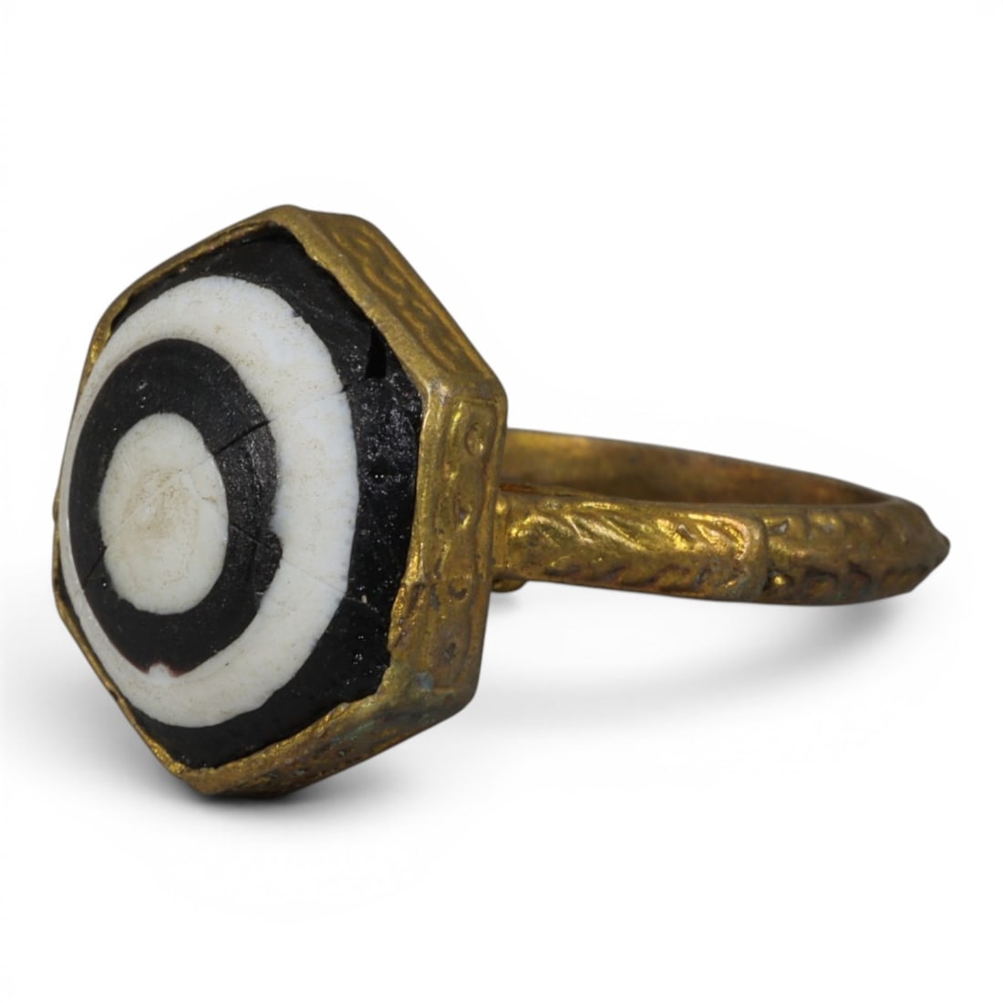 Antique Qajar Dynasty Gilt Evil Eye Ring, US Size 8.5, 52AJ: A gilt-metal ring of the Qajar period, US ring size 8.5, featuring a hexagonal evil-eye glass inlay with concentric black, white, and dark layers set within an ornate gilt bezel. The bezel and wide ba