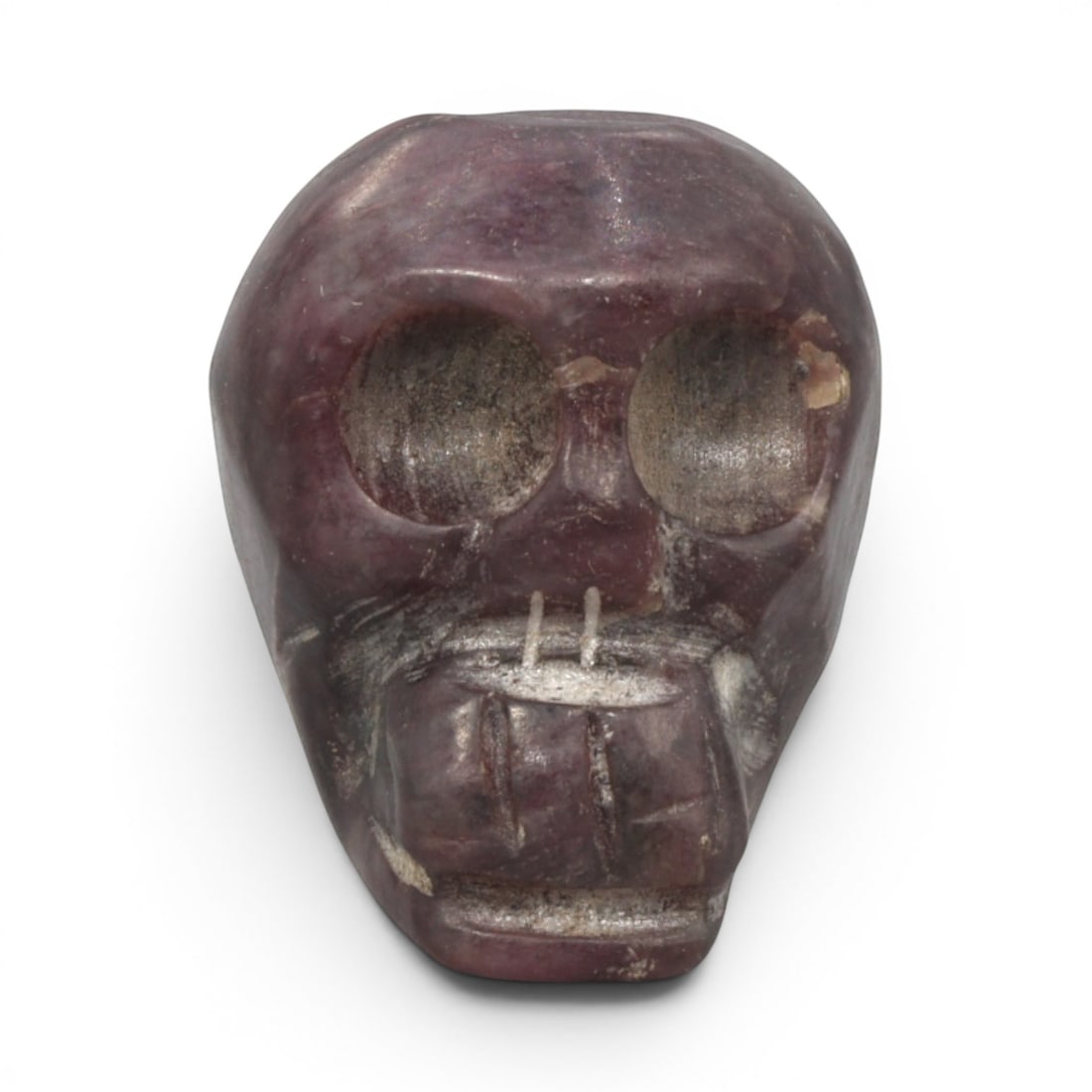 Antique Tibetan Purple Stone Skull Bead, 1AD: Carved from natural purple stone with a rich variegated hue and crystalline texture, the bead is shaped as a stylized human skull. The front face features large, hollowed eye sockets, a simplified nas
