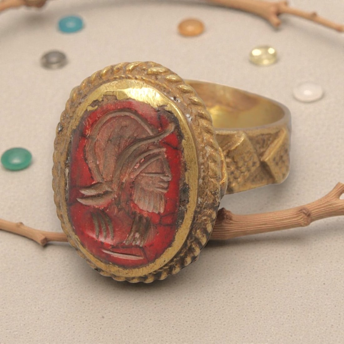 Antique Qajar Dynasty Gilt Intaglio Ring, US Size 9.5, 38WS: This ring features an oval red stone intaglio carved with a bearded male profile bust, executed in the glyptic style characteristic of Qajar period Iran. The red stone displays natural fissuring and a