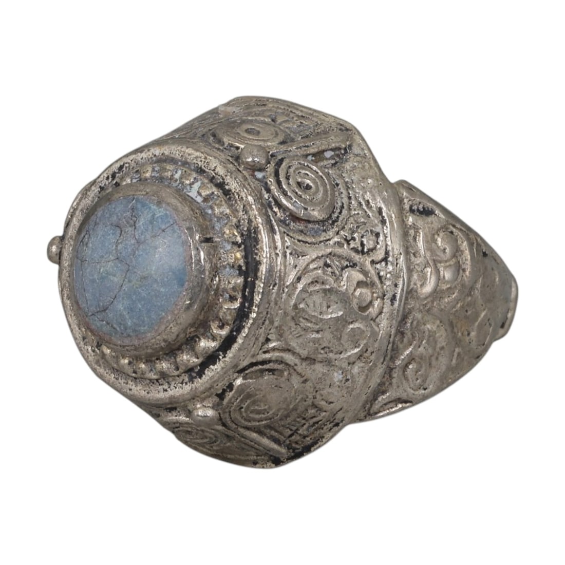 A Middle Eastern Silver Plated Turquoise Ring, Late 19th-Early 20th Century, 15AK: The ring is centered with a round cabochon turquoise stone exhibiting natural light blue tones and surface veining, set within a domed bezel framed by a beaded border. The bezel and shoulders are engr