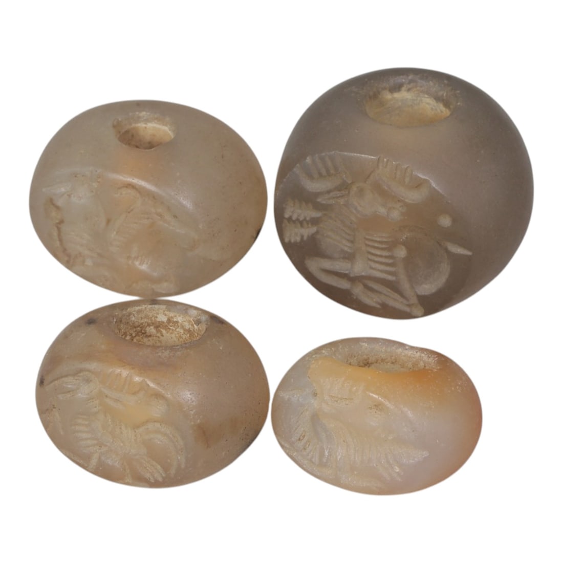 Lot of 4 Sasanian Agate Stamp Seals, Circa 3rd-7th Century CE, 15AG: Comprising four seals carved from translucent agate with natural pale to light orange tones, exhibiting surface patina and minor wear consistent with ancient use. Each seal is of flattened disc form w