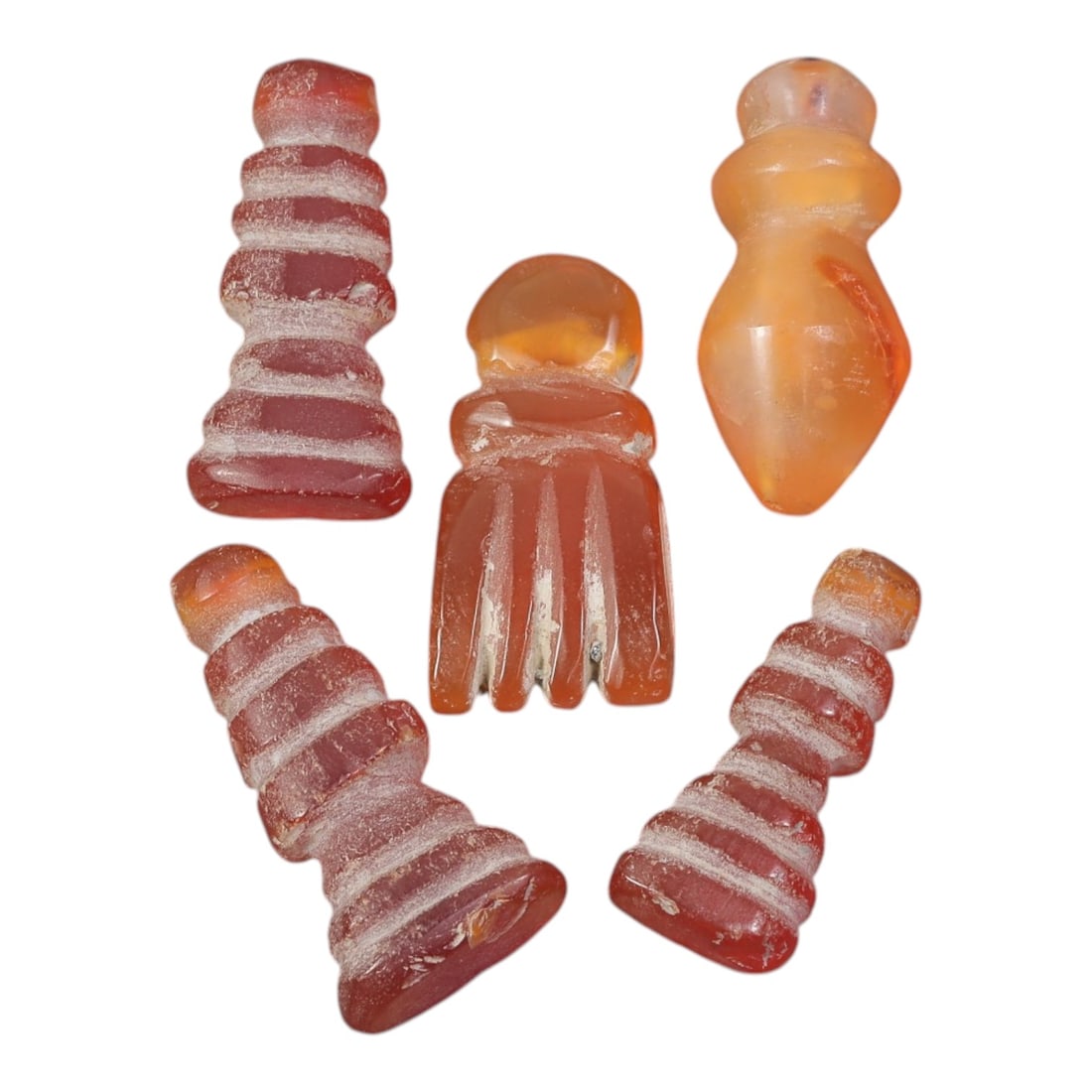Lot of 5 Ancient Coptic Egyptian Carnelian Amulets, Circa Roman Period to Coptic Era, 81AD: Comprising five finely carved carnelian amulets, each approximately 2 cm in height, this collection features characteristic forms from Coptic Egyptian amuletic traditions. The pieces include tiered an