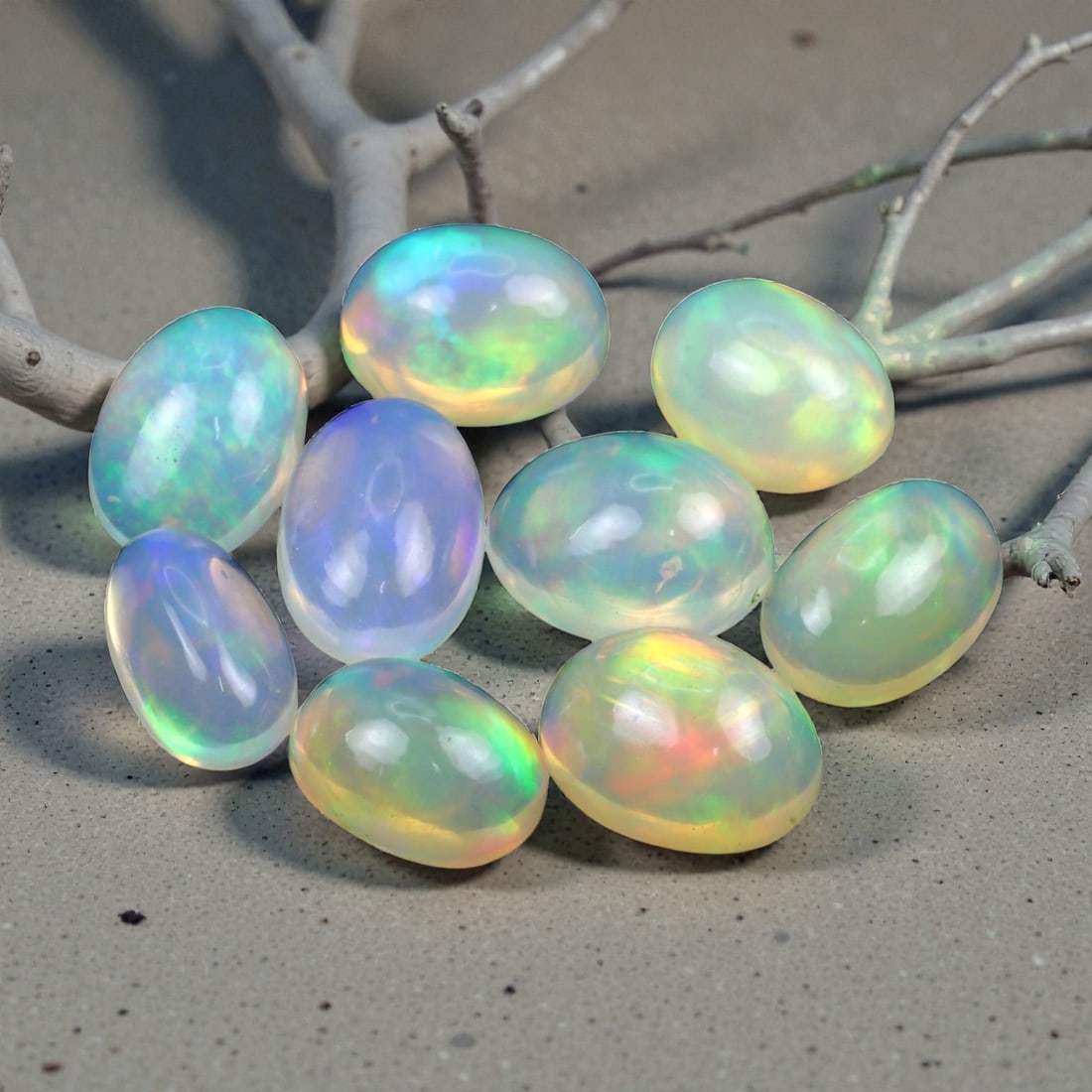 12.85 Carats Neon Play-of-Color Opal Selection - Natural Ethiopian Cabochons - 8 to 10 mm, 12XE: This luminous selection of opals radiates a dynamic spectrum of neon hues, with flashes of electric green, vivid orange, and spectral blue dancing across each dome. Their translucent base allows the i