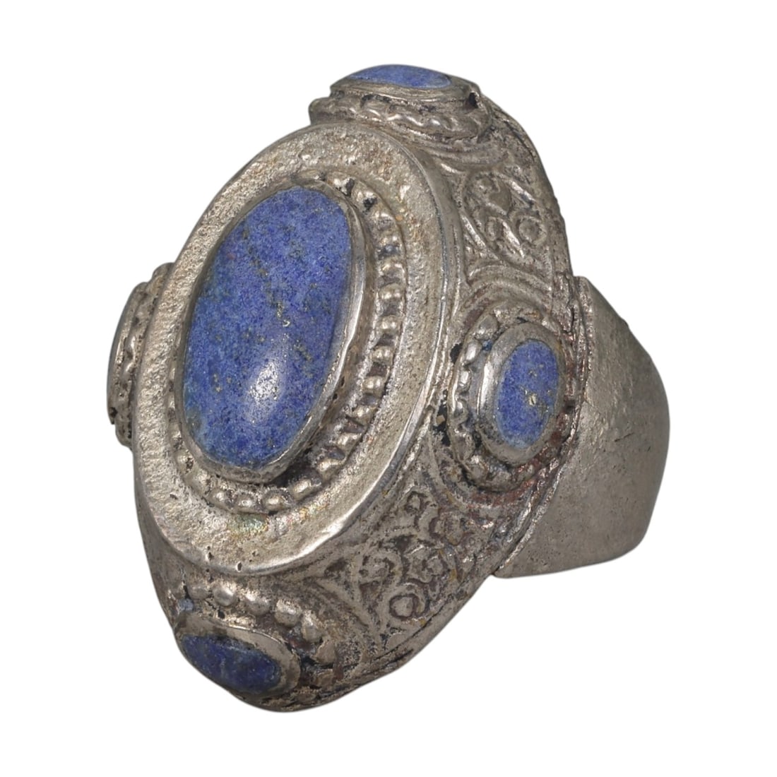 A Middle Eastern Silver Plated Multi-Stone Lapis Lazuli Ring, Late 19th-Early 20th Century, 37AK: Set with a central oval cabochon lapis lazuli stone exhibiting deep blue color with natural pyrite flecks, the ring is accented by four smaller lapis lazuli stones arranged around the bezel. The centr