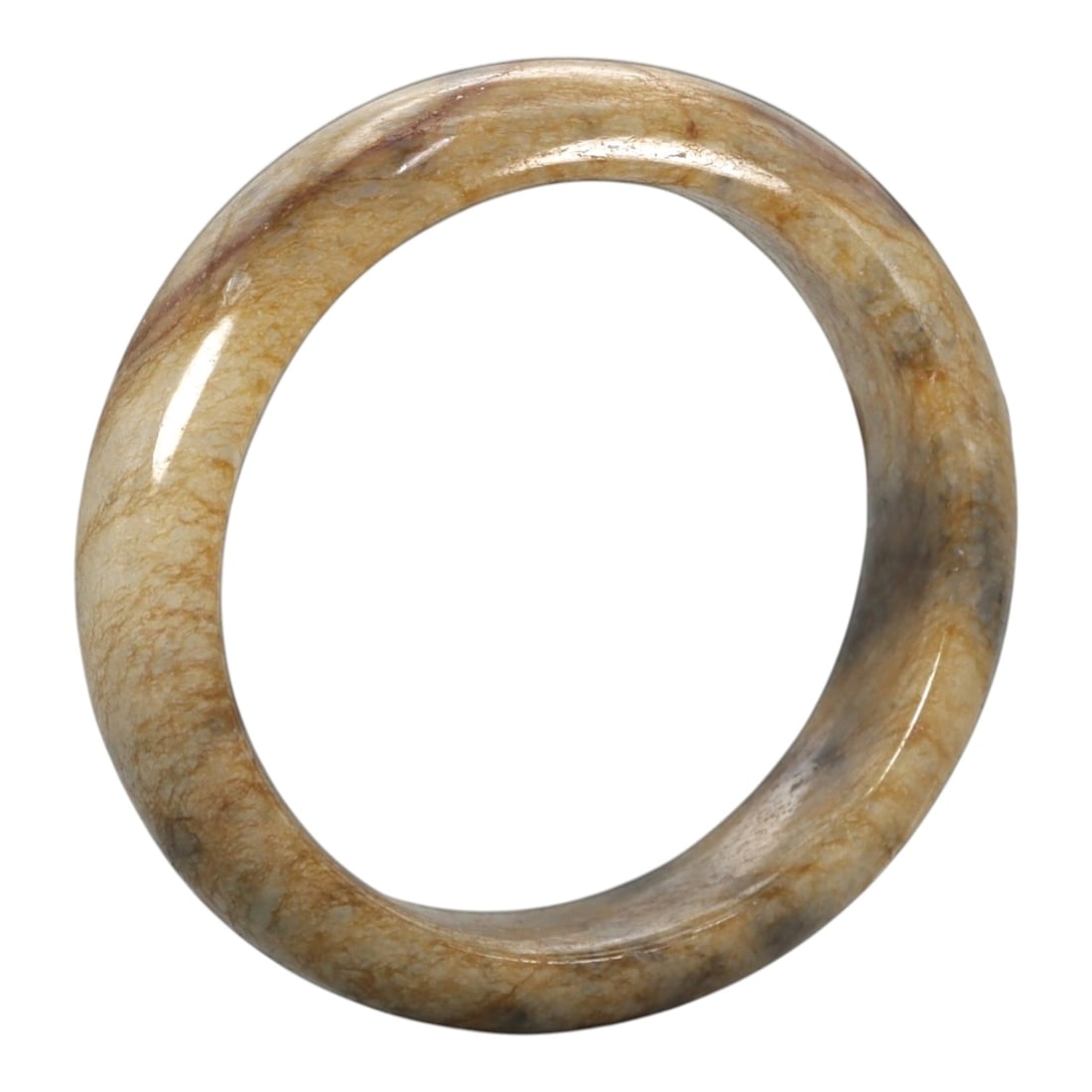 A Chinese Jadeite Jade Bangle Bracelet, 20th Century, 91ZK: Carved from jadeite jade with a pale creamy-tan base and fine, irregular brownish veining throughout, the bangle is formed as a continuous circular band with a rounded cross-section. The surface is sm