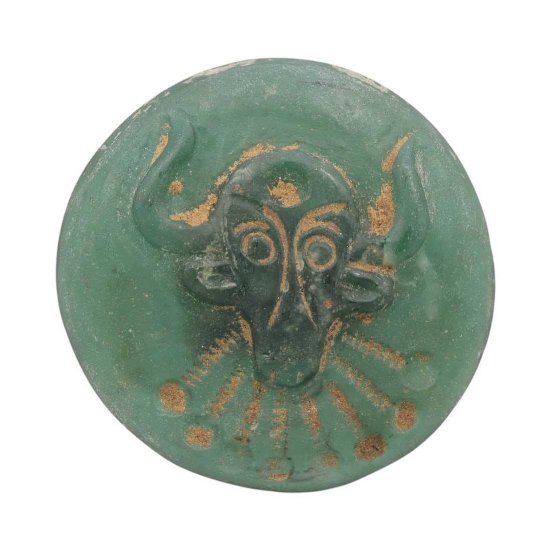 An Ancient Roman Glass Bull Amulet Pendant, 24AH: A single ancient-style glass amulet pendant, crafted from translucent turquoise Roman glass, measuring approximately 5 cm in diameter. The pendant features a deeply incised bull's head motif with prom