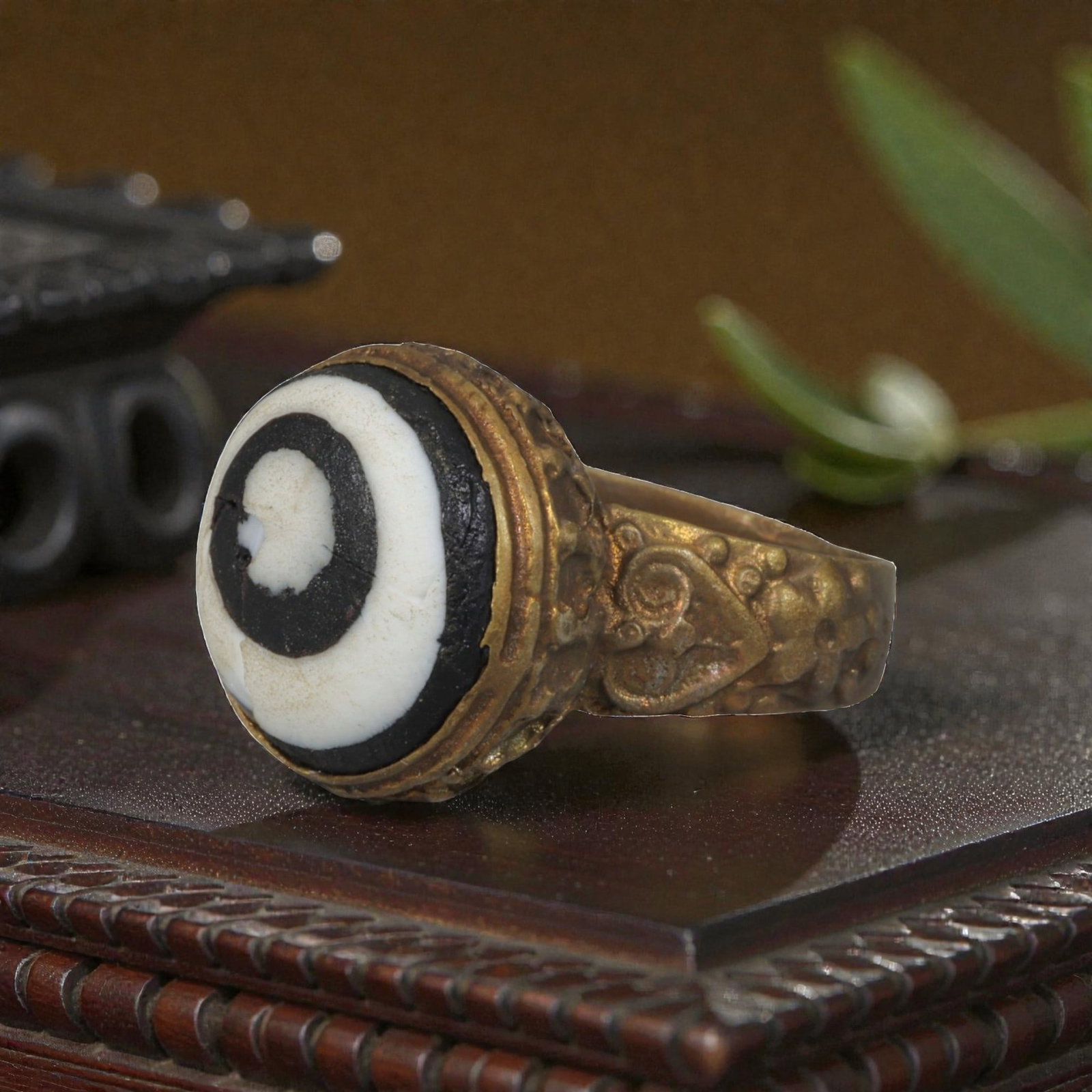 Antique Qajar Dynasty Gilt Evil Eye Ring, US Size 8.5, 10AJ: A gilt-metal ring of the Qajar period, US ring size 8.5, featuring a large domed evil-eye glass inlay with a bold concentric black-and-white design. The bezel is decorated with a textured, bubble-like