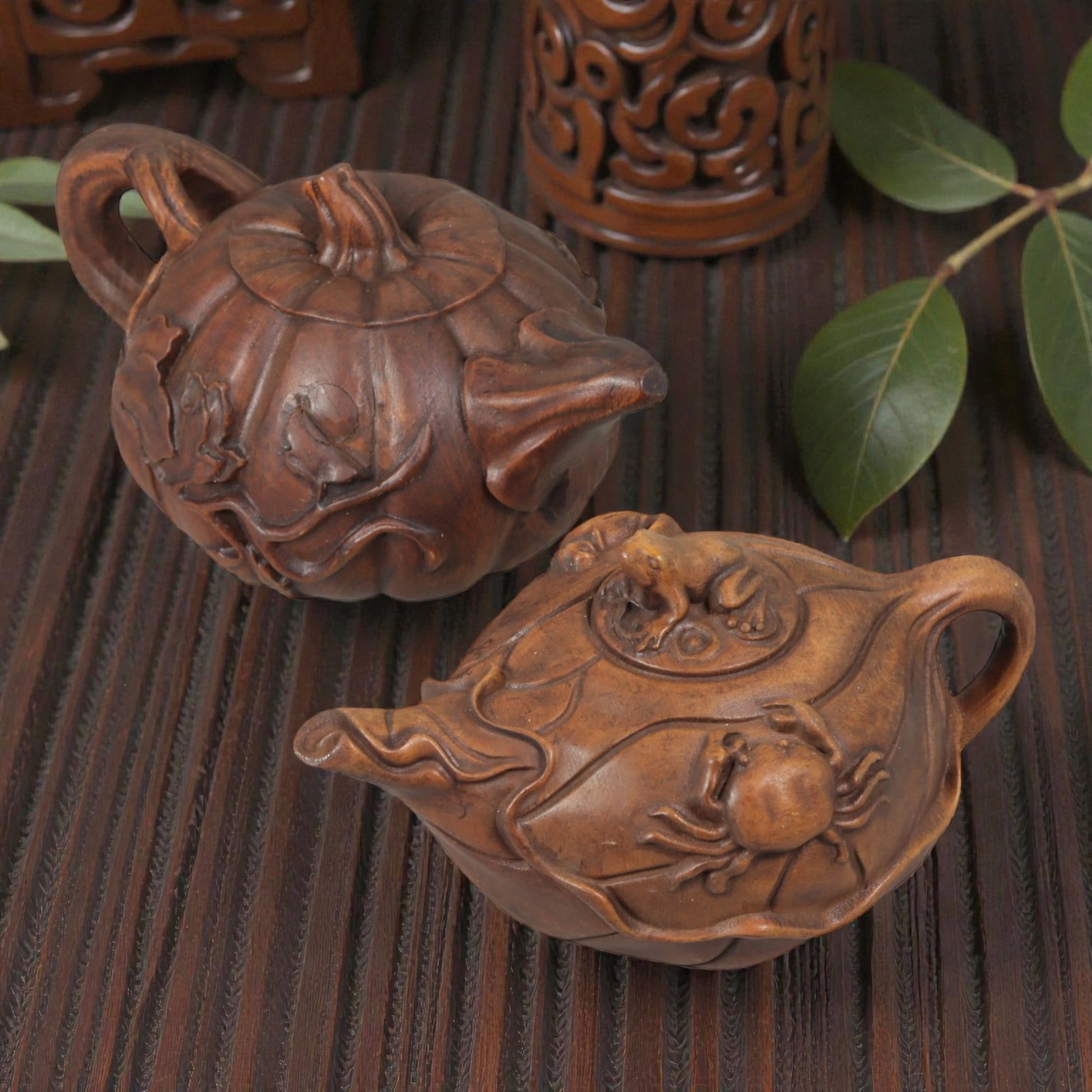 Lot of 2 Vintage Oriental Chinese Carved Wood Teapots, 66AG: Carved from solid wood with a rich, warm brown patina, the two teapots are each modeled in naturalistic forms. The first teapot is shaped as a pumpkin, with vertical fluting mimicking the segmented ri