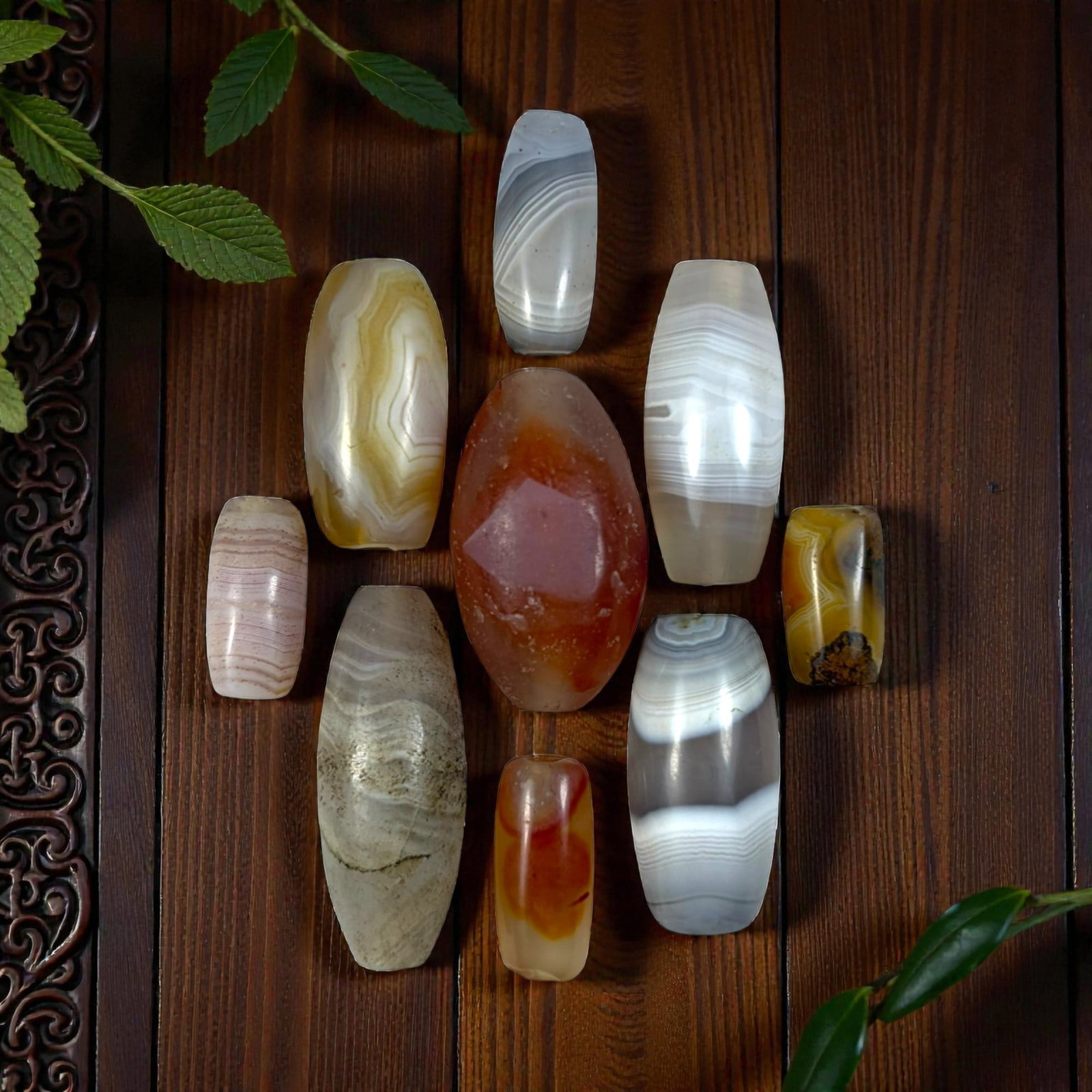 A Lot of 9 Himalayan Banded Agate Beads, Ancient to Antique Period, 22YD: Comprising lot of barrel and ovoid beads, each carved from banded agate with natural tonal variations, many displaying characteristic concentric, linear, and dendritic patterns. The surfaces exhibit s