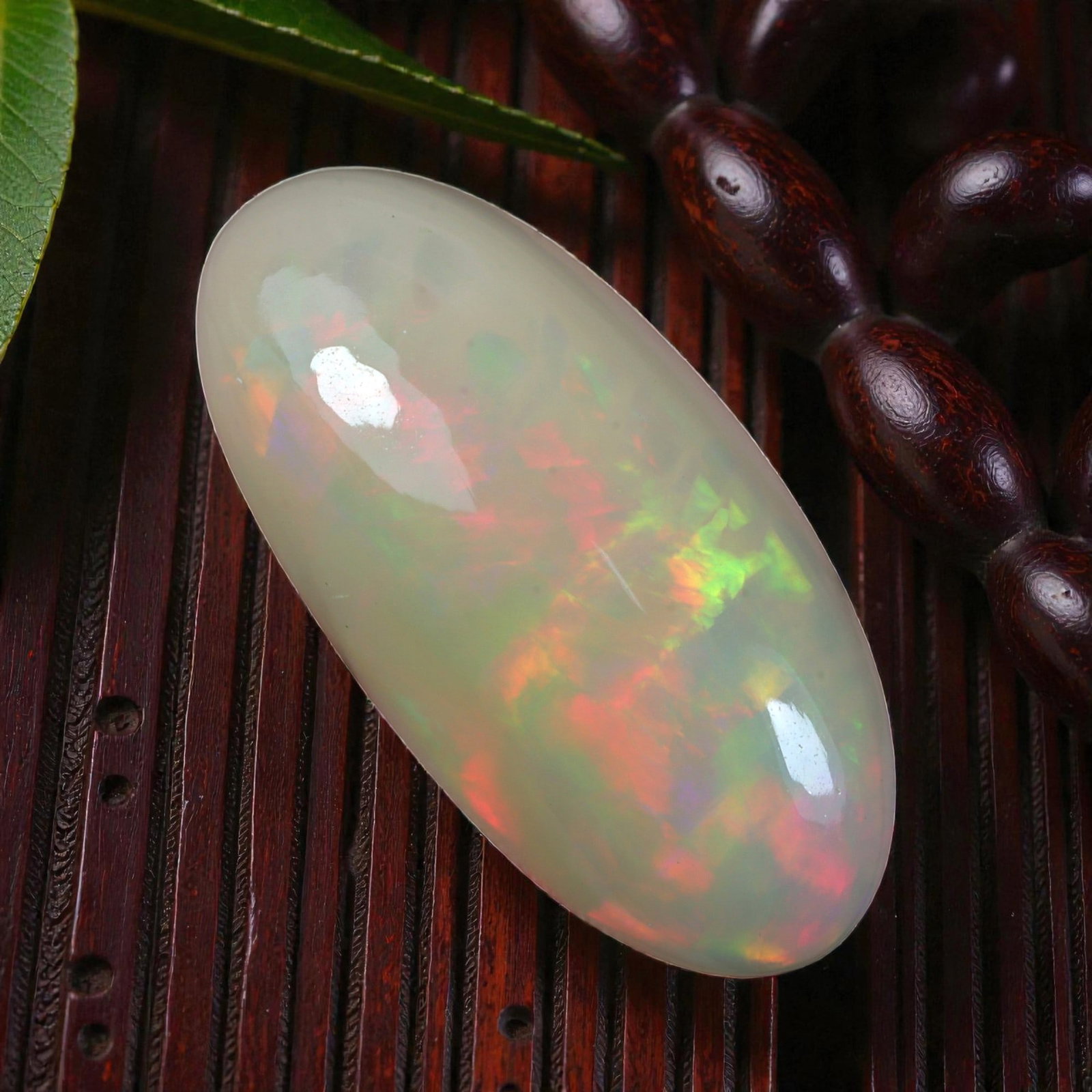6.70 Carats Welo Opal Oval Cabochon - Natural Ethiopian Stone, 5XB: This stunning oval cabochon of Welo opal captivates with a mesmerizing play of color, featuring broad, sweeping flashes of vivid red, lime green, and golden orange against a creamy translucent base. T