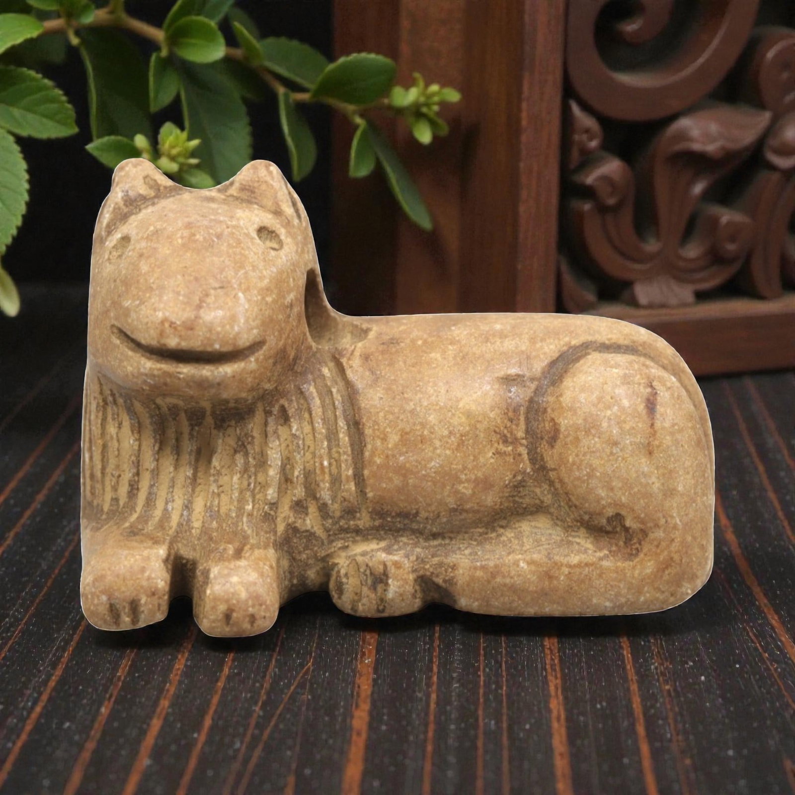 Ancient Stone Feline Figurine - Near Eastern Amulet, 4ZR: Carved from warm tan stone, this reclining feline figurine features a stylized head with incised eyes, pointed ears, and a gently curved mouth. The neck displays linear incised detailing suggesting a 