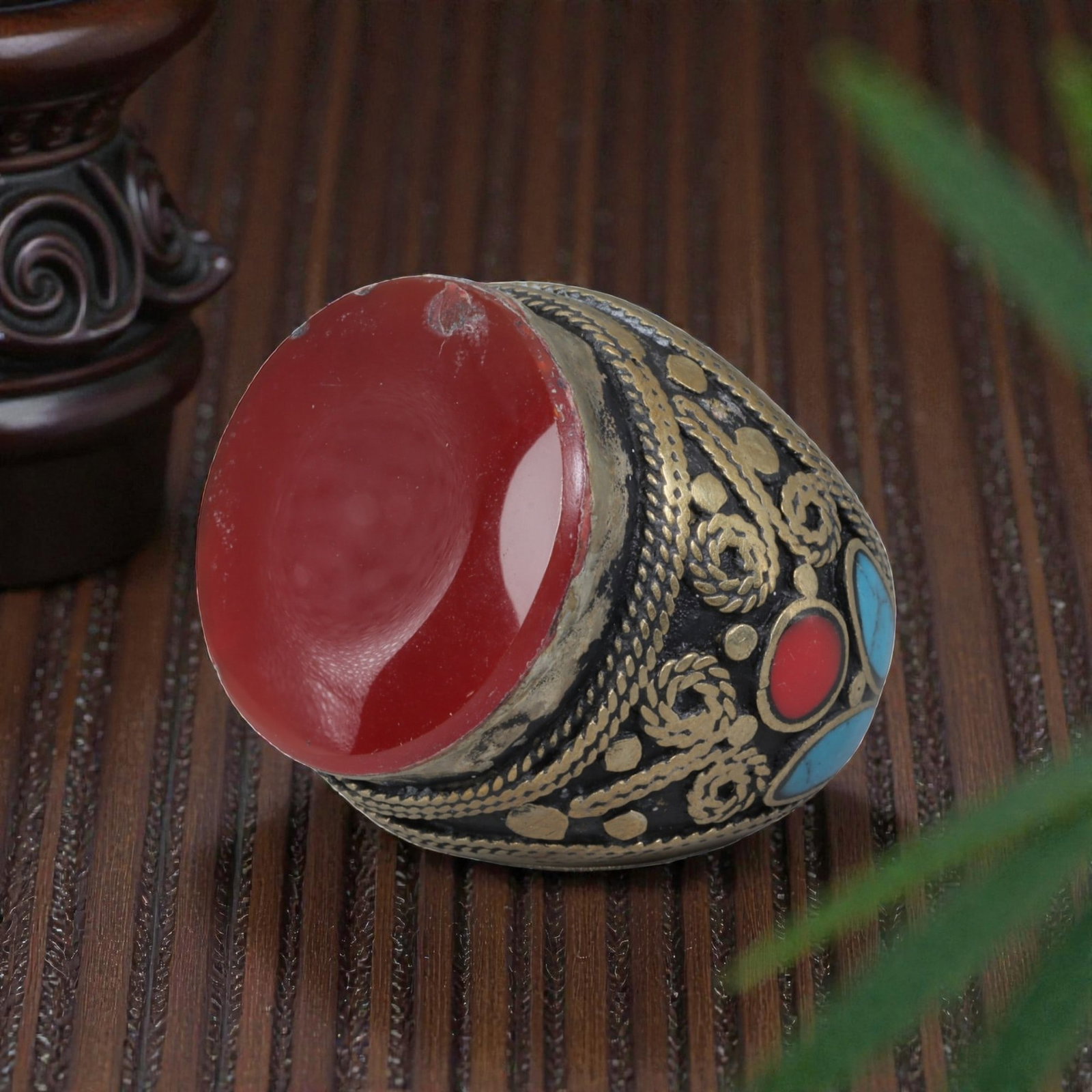 Antique Central Asian Silver and Carnelian Tribal Ring, 19th-Early 20th Century, 67AJ: The ring is set with a large, smooth cabochon carnelian stone, exhibiting minor surface wear. The silver mount is decorated with pseudo-filigree wirework, applied coiled motifs, and inlaid turquoise a