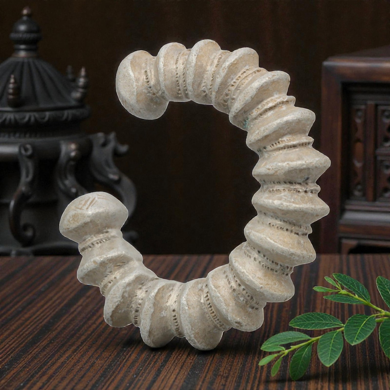 An African Silvered Aluminium Bracelet, 20th Century, 97FT: Formed from silvered aluminium, the bracelet is constructed as an open C-shape, composed of a series of stacked, disc-like segments separated by fine, incised linear bands. The terminals are rounded a