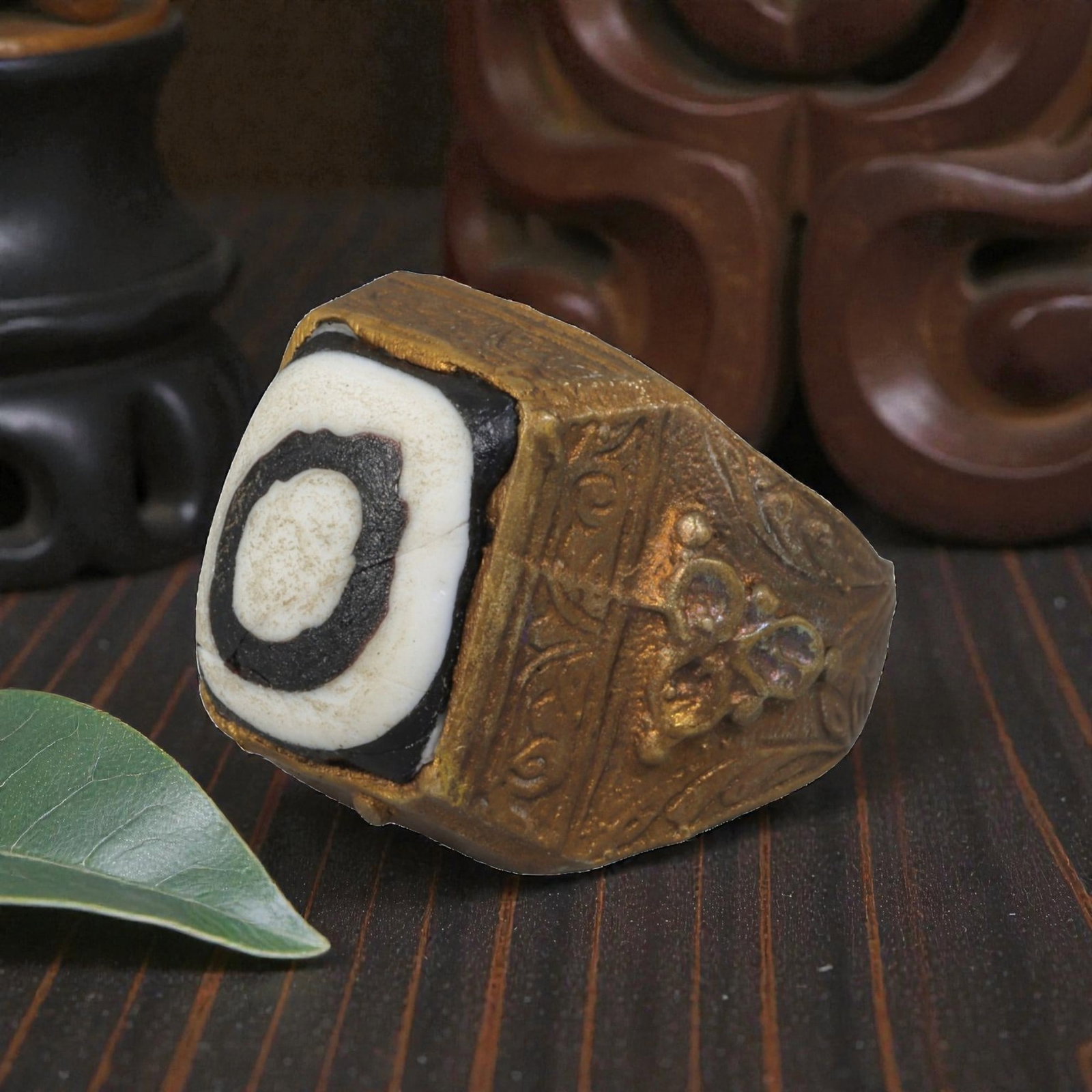 Antique Qajar Dynasty Gilt Evil Eye Ring, US Size 10, 15AJ: A gilt-metal ring of the Qajar period, US ring size 10, featuring a large square evil-eye glass inlay with a concentric black-and-white design (the glass exhibits age-related cracks). The bezel and wi
