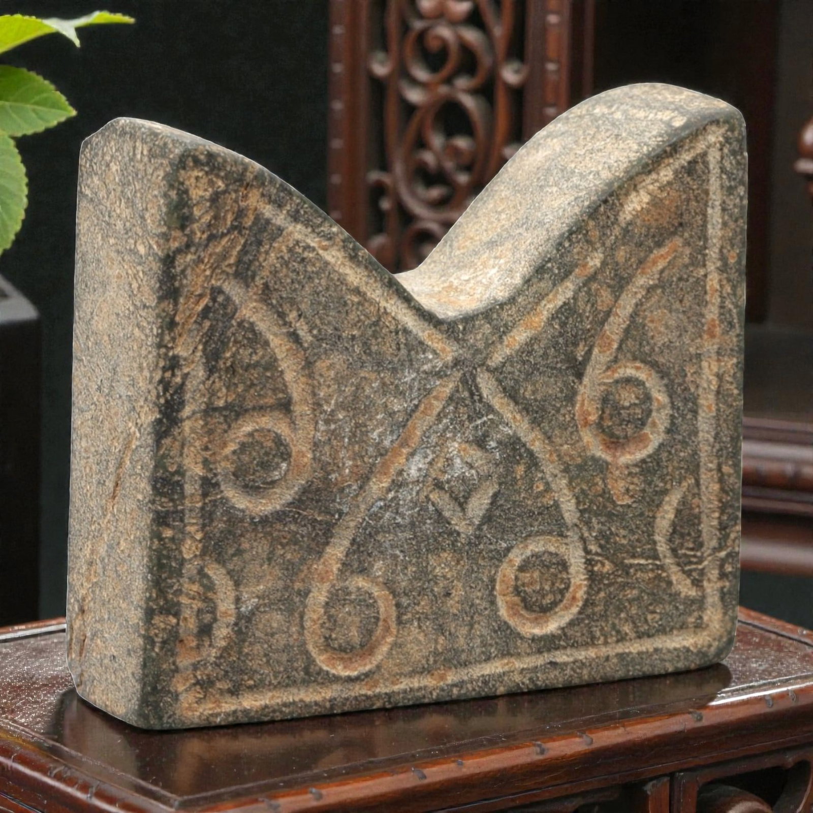 An Ancient Carved Stone Relic, 2nd-1st Millennium BCE, 30FL: Carved from dark gray stone with natural surface weathering and orange-brown incised patina, the object is formed as a block with a notched upper edge. The front face features incised curvilinear patt