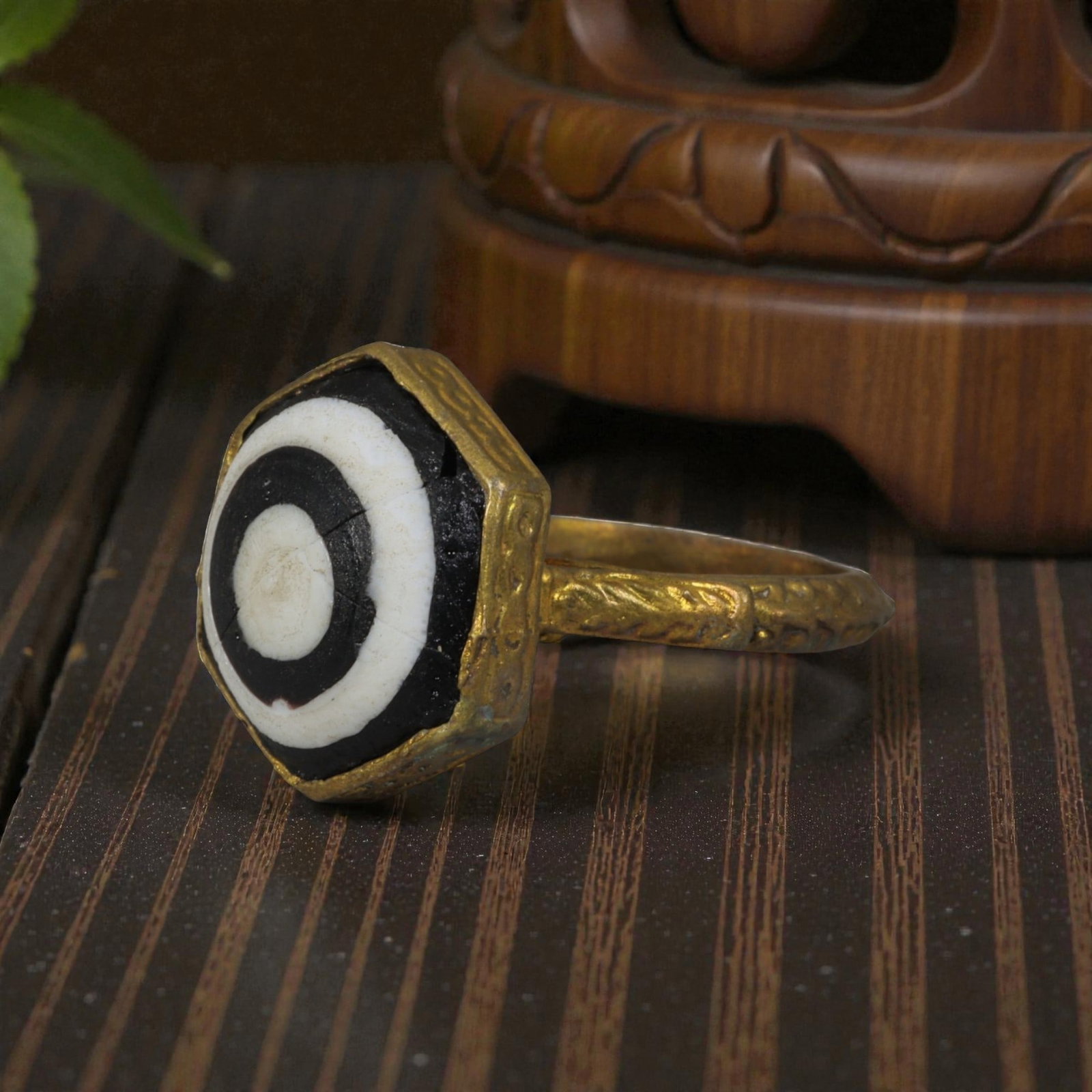 Antique Qajar Dynasty Gilt Evil Eye Ring, US Size 8.5, 52AJ: A gilt-metal ring of the Qajar period, US ring size 8.5, featuring a hexagonal evil-eye glass inlay with concentric black, white, and dark layers set within an ornate gilt bezel. The bezel and wide ba