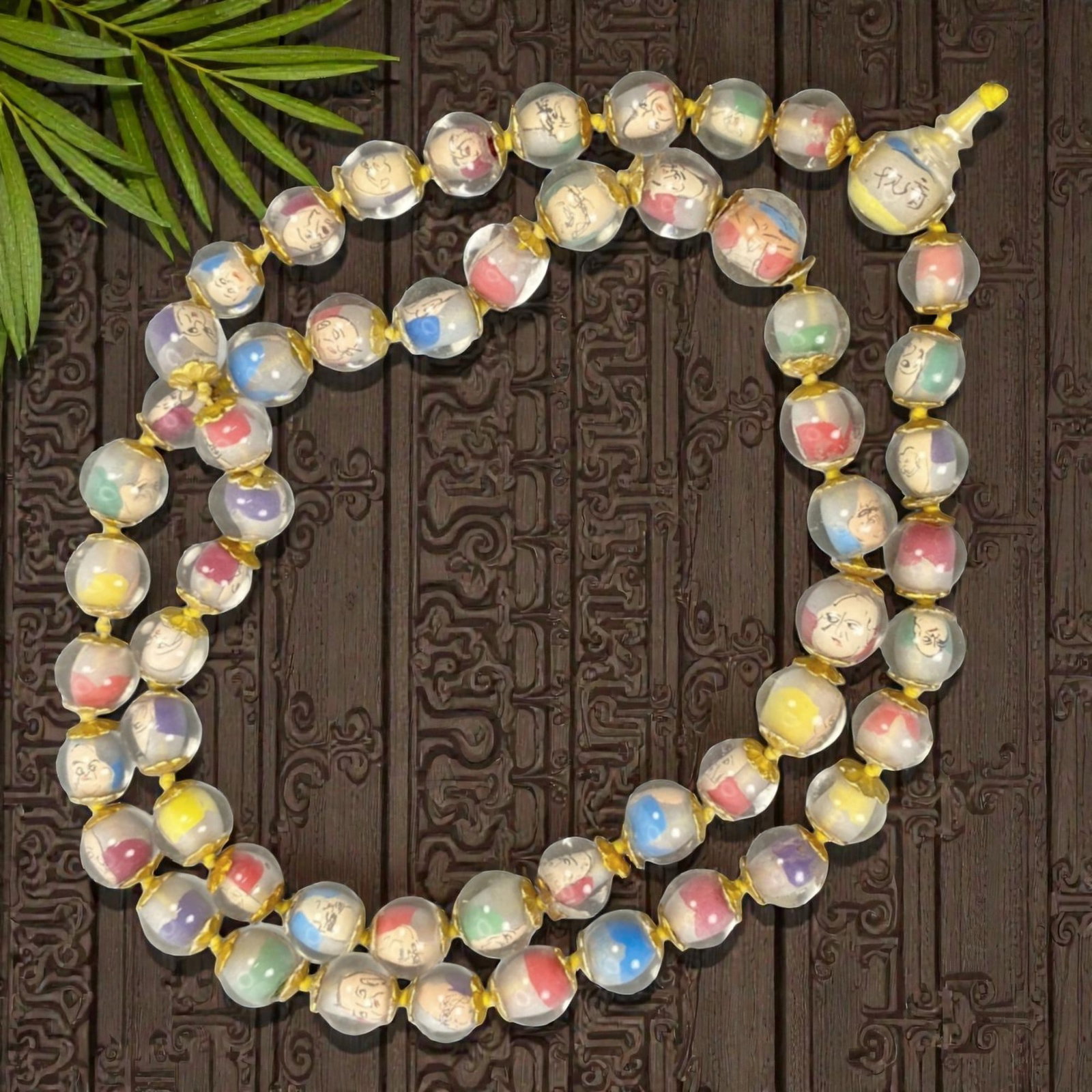A Chinese Glass Beaded Necklace with Inner Painting, 20th Century, 38FJ: The necklace is composed of a long strand of spherical transparent glass beads, each finely decorated with inner-painted figural portraits rendered in black line against softly colored grounds of red,