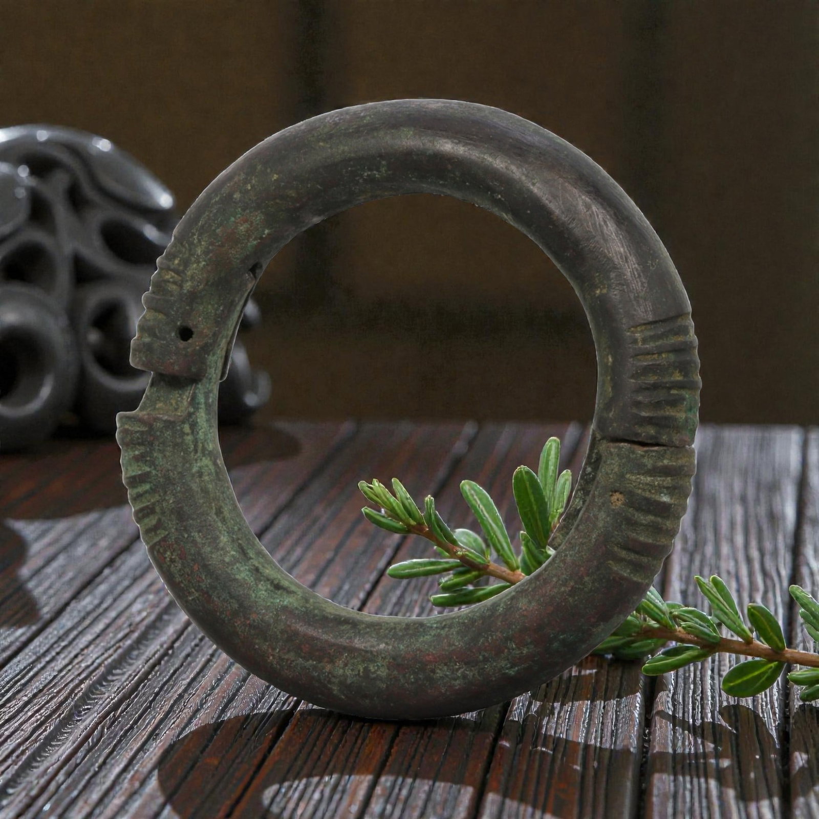Ancient Bronze Bracelet - Roman Decorated Penannular Bangle, 78BN: A penannular bronze bracelet of ancient Roman origin, formed from a thick, rounded bronze band with substantial cross-section. The open terminals are decorated with deeply incised linear grooves, crea