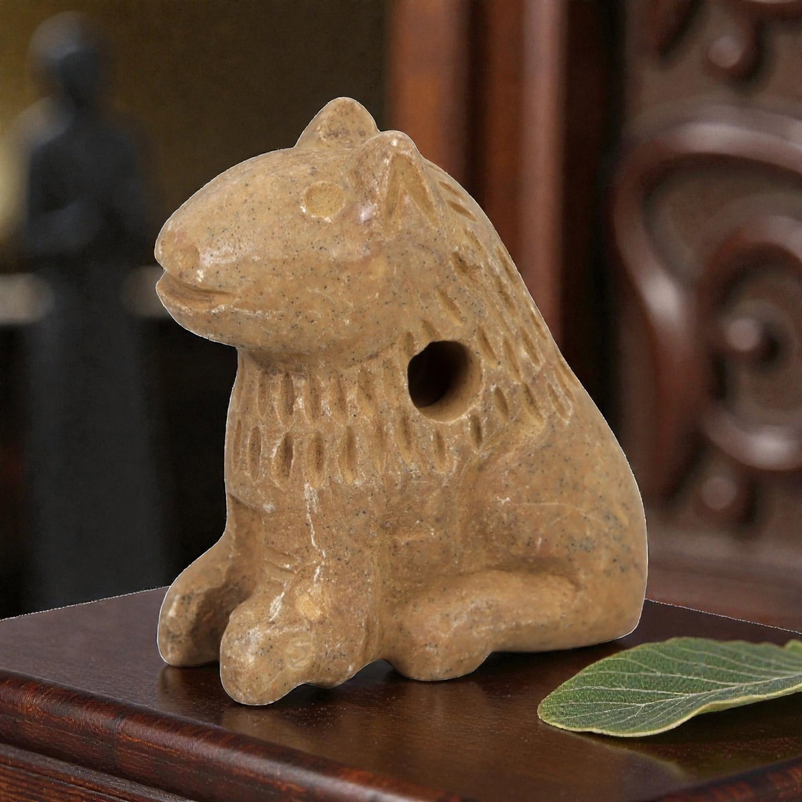 Ancient Stone Feline Amulet - Near Eastern Lion / Cat Figure, 39AM: This amulet is carved from warm beige stone with natural speckling and a smooth, weathered patina, depicting a stylized feline (lion or big cat) in a seated, alert posture. The piece features incised 