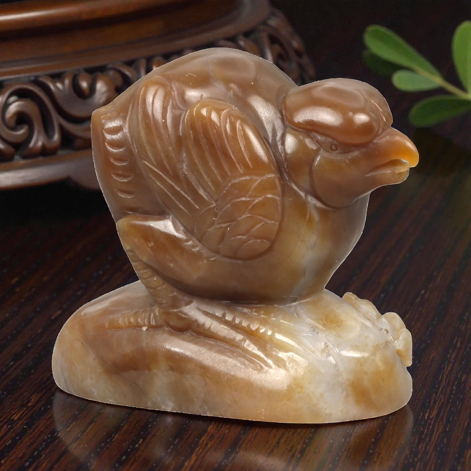 A Chinese Jade Bird Sculpture, 20th Century, 33YA: Carved from warm amber-brown jade with areas of pale creamy translucency, the sculpture depicts a bird shown in profile, perched upon a naturalistic base. The bird is rendered with a rounded body and 