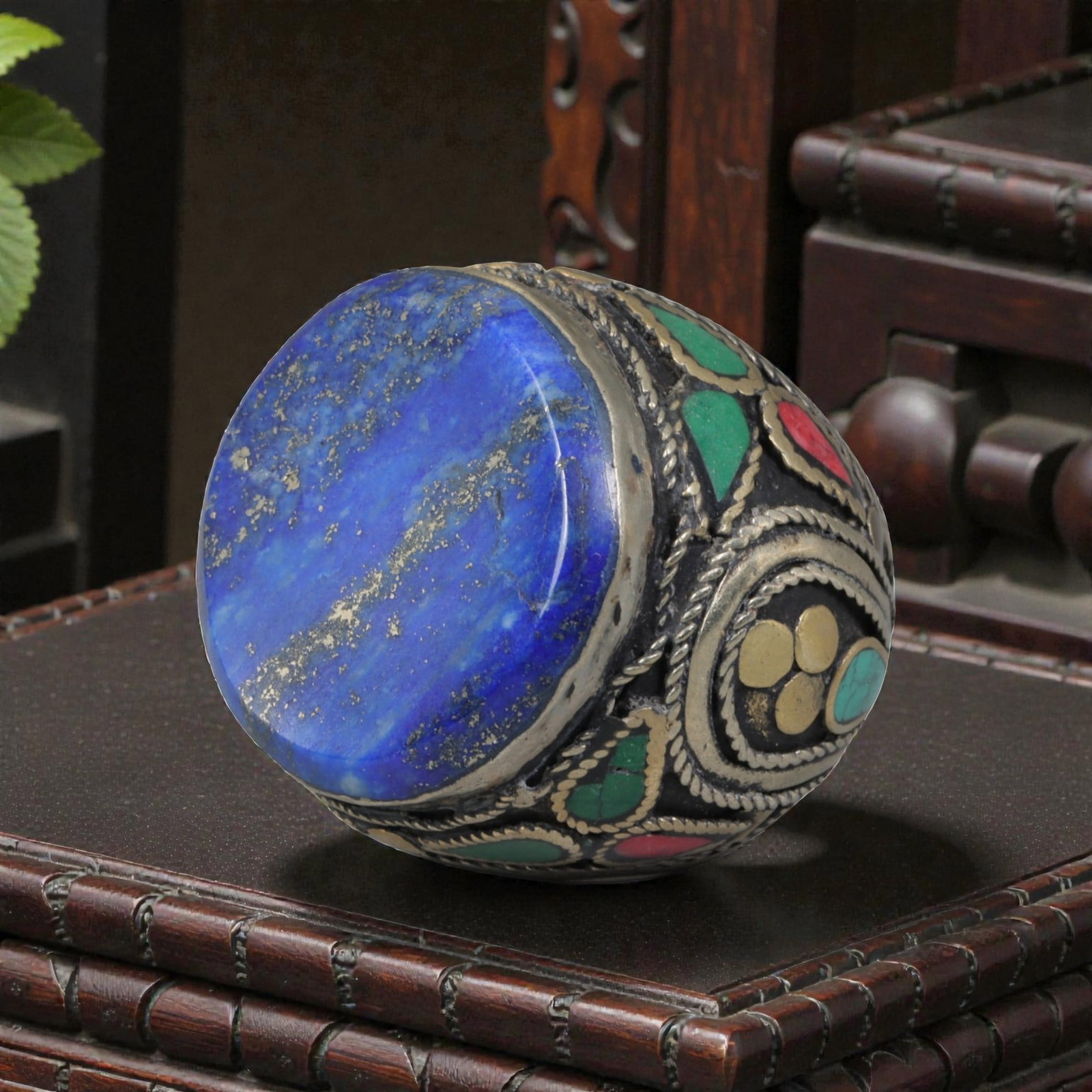 Antique Central Asian Silver and Lapis Lazuli Tribal Ring, 19th-Early 20th Century, 65AJ: The ring is set with a large, flat cabochon lapis lazuli stone, displaying characteristic pyrite inclusions within its deep blue matrix. The silver mount is decorated with pseudo-filigree wirework and