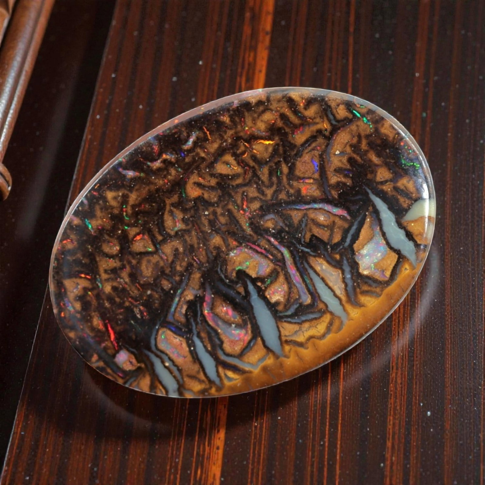5.61 Carats Color-Flecked Koroit Boulder Opal - Natural Australian Stone, LZ45: This magnificent 5.61 carat Koroit boulder opal, measuring 15.2mm x 10.9mm x 3.2mm, is a breathtaking showcase of nature's complexity. Polished into a smooth oval cabochon, its face features a rich, t