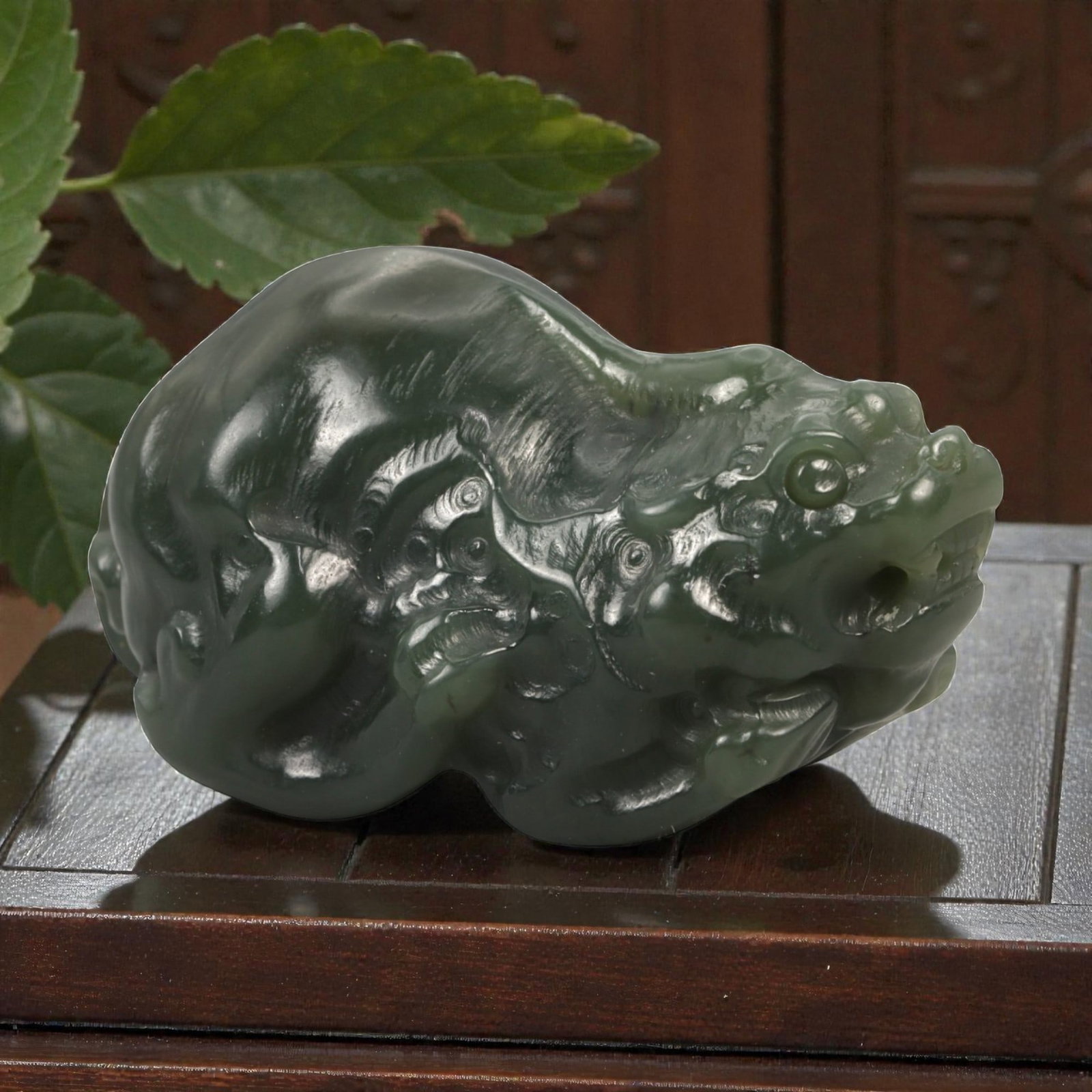 Chinese Dark Green Jade Pi Xiu - Guardian Beast Figurine, 88ZD: Carved from dense, dark green jade with a high-polish finish, this compact sculptural figure depicts a pi xiu in a powerful crouching posture. The mythical creature is rendered with a pronounced drago