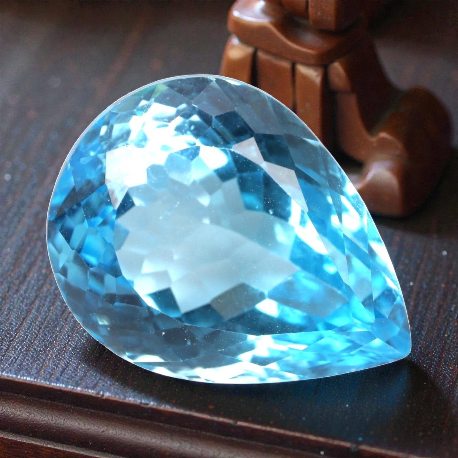 37.64 Carats Swiss Blue Topaz Pear - Natural Brazilian Stone, LZ108: This magnificent pear-cut Swiss blue topaz radiates with a vibrant, icy blue hue that evokes the clarity of alpine lakes and glacial skies. The gem is masterfully faceted, with precisely angled surfac