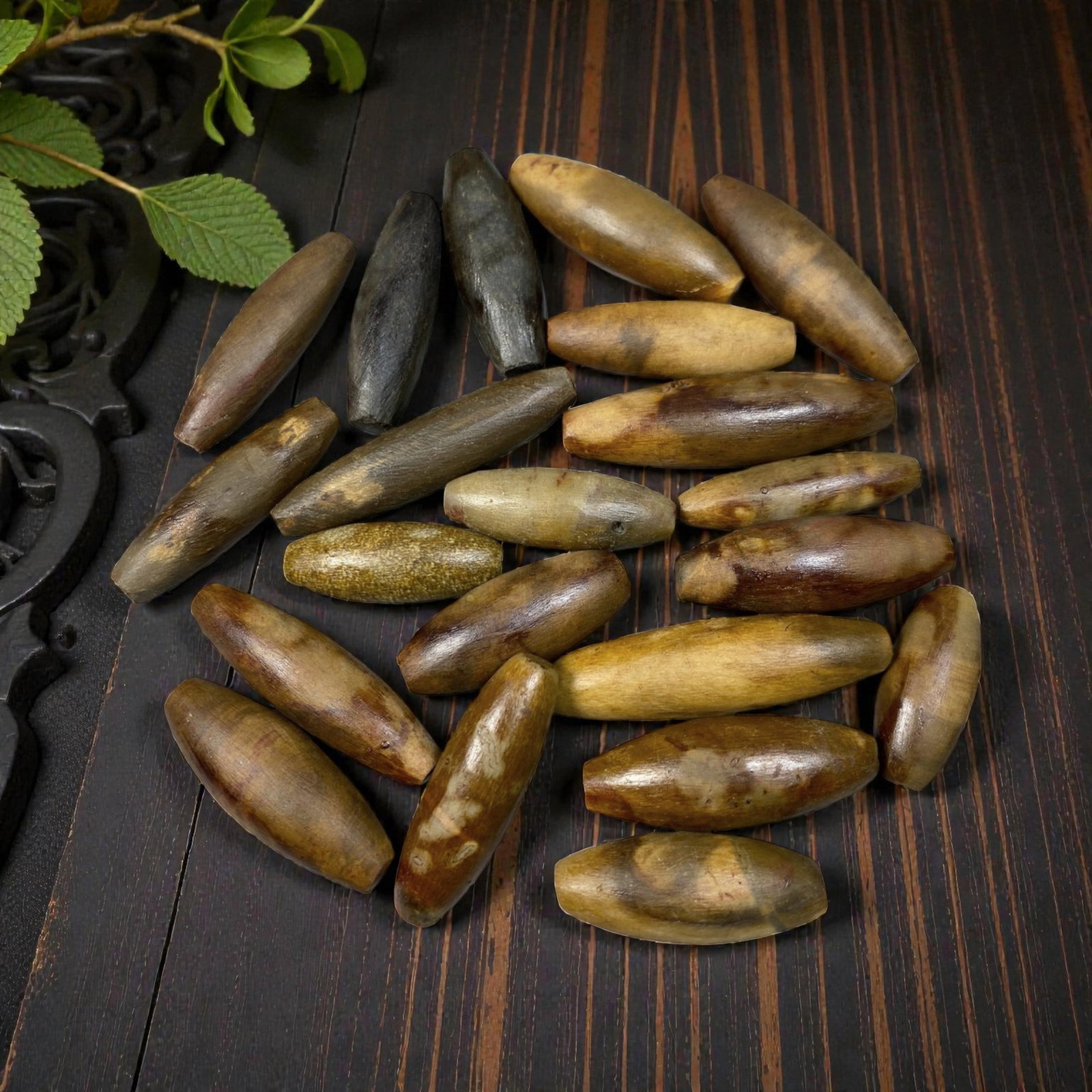 Lot of 21 Antique Himalayan Tibetan Fossilized Wood Ritual Beads, 67AG: A collection of 21 antique Himalayan Tibetan ritual beads, carved from natural fossilized wood with rich, earthy hues ranging from warm amber and golden brown to deep black. Each bead is shaped into a