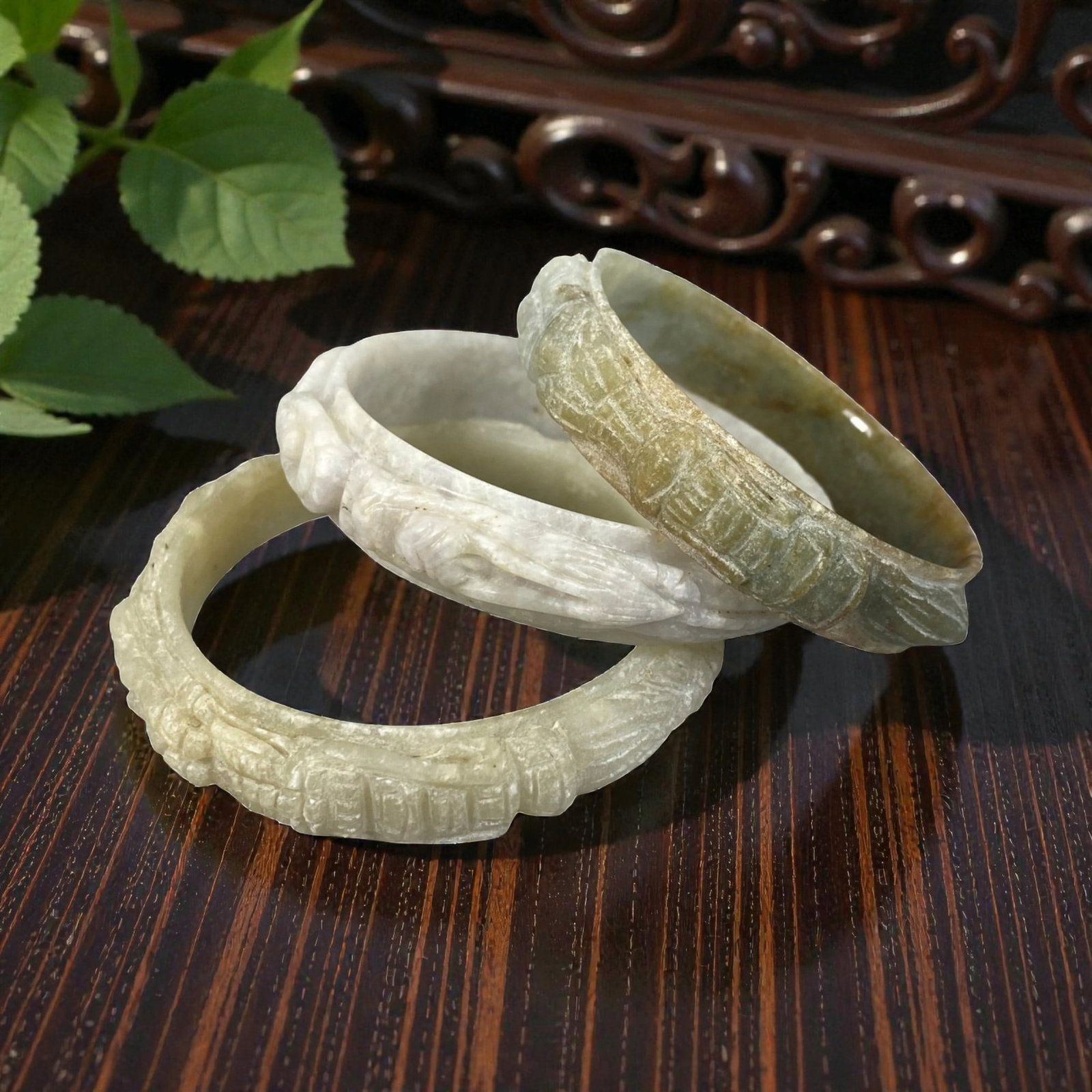 Lot of 3 Chinese Carved Jadeite Jade Bracelets (Bangles), 87AC: Each bracelet is carved from jadeite with varied natural coloration and inclusions, including pale off-white with faint lavender undertones, creamy beige, and mottled grey-green with brownish hues. Th
