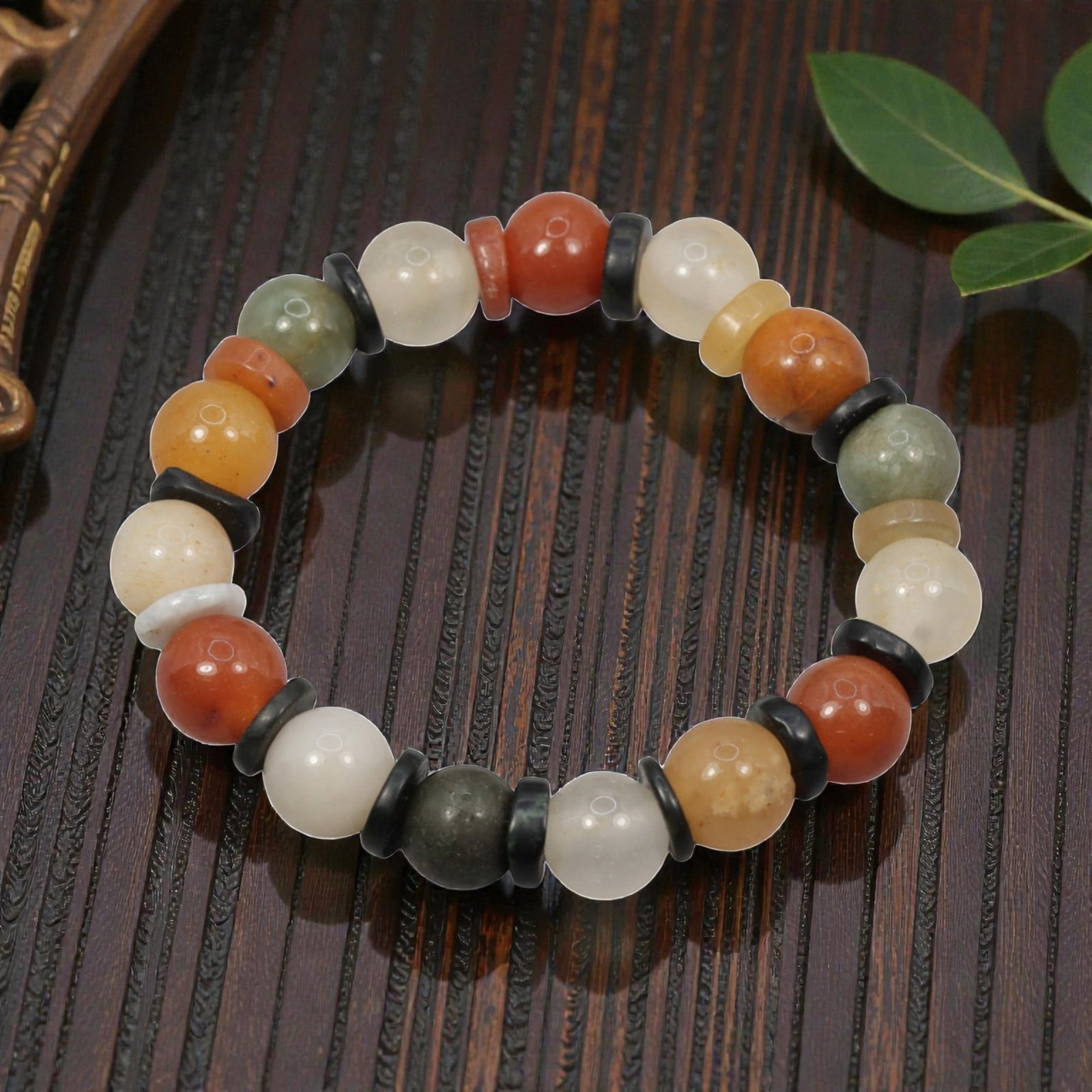 A Chinese Quartz and Jadeite Jade Bead Bracelet, 20th Century, 48ZK: Strung with spherical beads of quartz and jadeite jade, separated by flat disc-shaped spacers. The quartz beads display natural color variation, including white, yellow, orange, and reddish-orange, wi