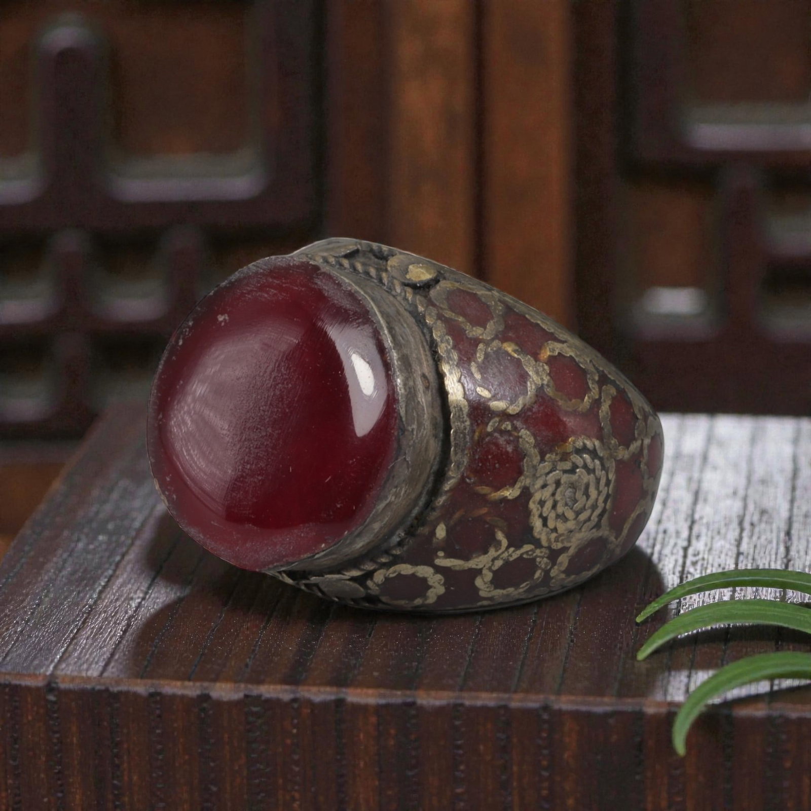 Antique Central Asian Silver and Carnelian Tribal Ring, 19th-Early 20th Century, 57AJ: The ring is set with a large, smooth cabochon carnelian stone. The silver mount is decorated with pseudo-filigree wirework over a red-enameled background, featuring applied coiled and circular motifs.