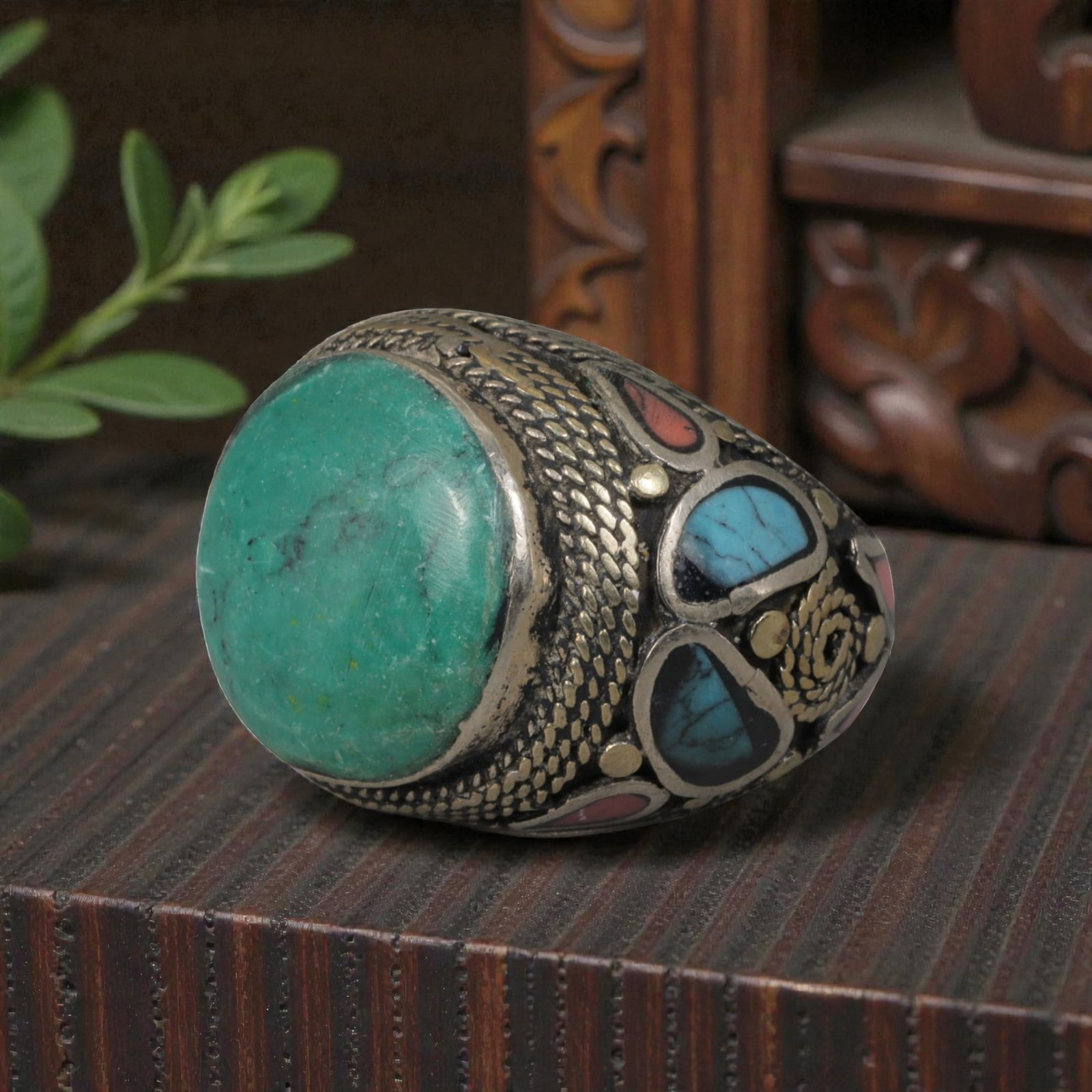 Antique Central Asian Silver and Turquoise Tribal Ring, 19th-Early 20th Century, 71AJ: The ring is set with a large, smooth cabochon turquoise stone, displaying natural matrix inclusions within its green-blue matrix. The silver mount is decorated with pseudo-filigree scale-pattern wirew