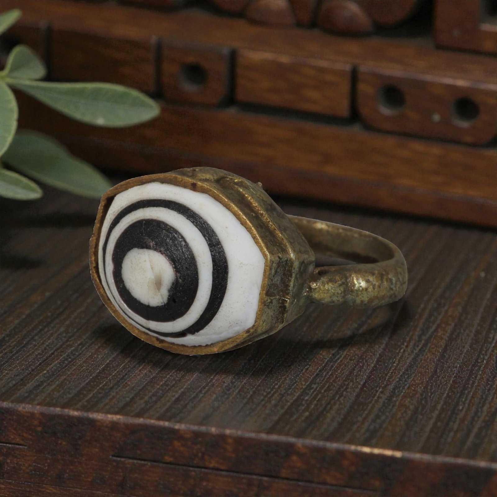 Antique Qajar Dynasty Gilt Evil Eye Ring, US Size 9, 42AJ: A gilt-metal ring of the Qajar period, US ring size 9, featuring an oval evil-eye glass inlay with a bold concentric black-and-white design (the glass exhibits age-related cracks). The bezel and band 