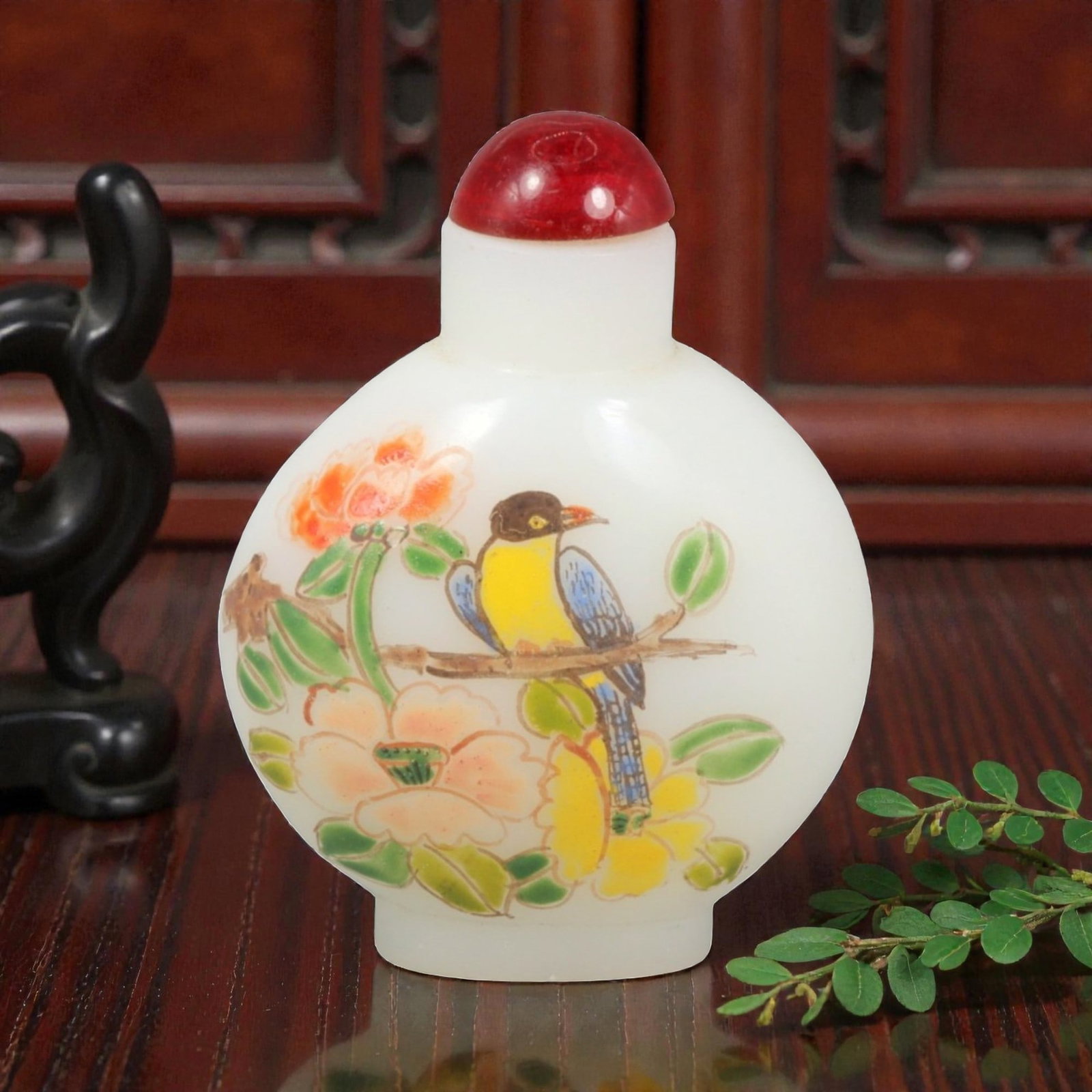 A Chinese Glass Painted Snuff Bottle, 20th Century, 13YC: The bottle is formed of translucent white glass and potted with a flattened globular body rising from a short circular foot to a cylindrical neck with a recessed mouth, fitted with a red glass stopper
