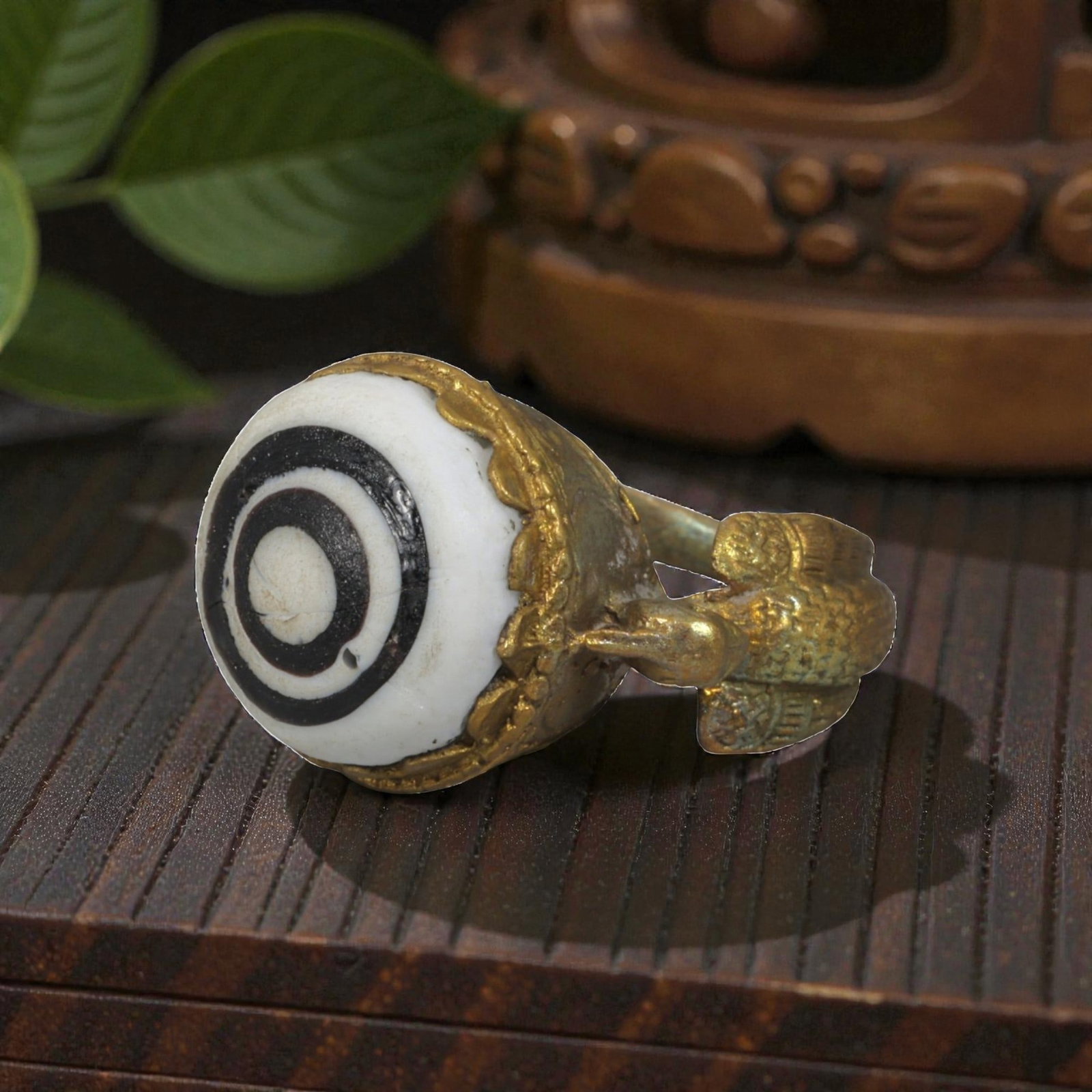 Antique Qajar Dynasty Gilt Evil Eye Ring, US Size 8.5, 6AJ: A gilt-metal ring of the Qajar period, US ring size 8.5, featuring a large domed evil-eye glass inlay with a bold concentric black-and-white design. The bezel is adorned with a decorative scalloped ed