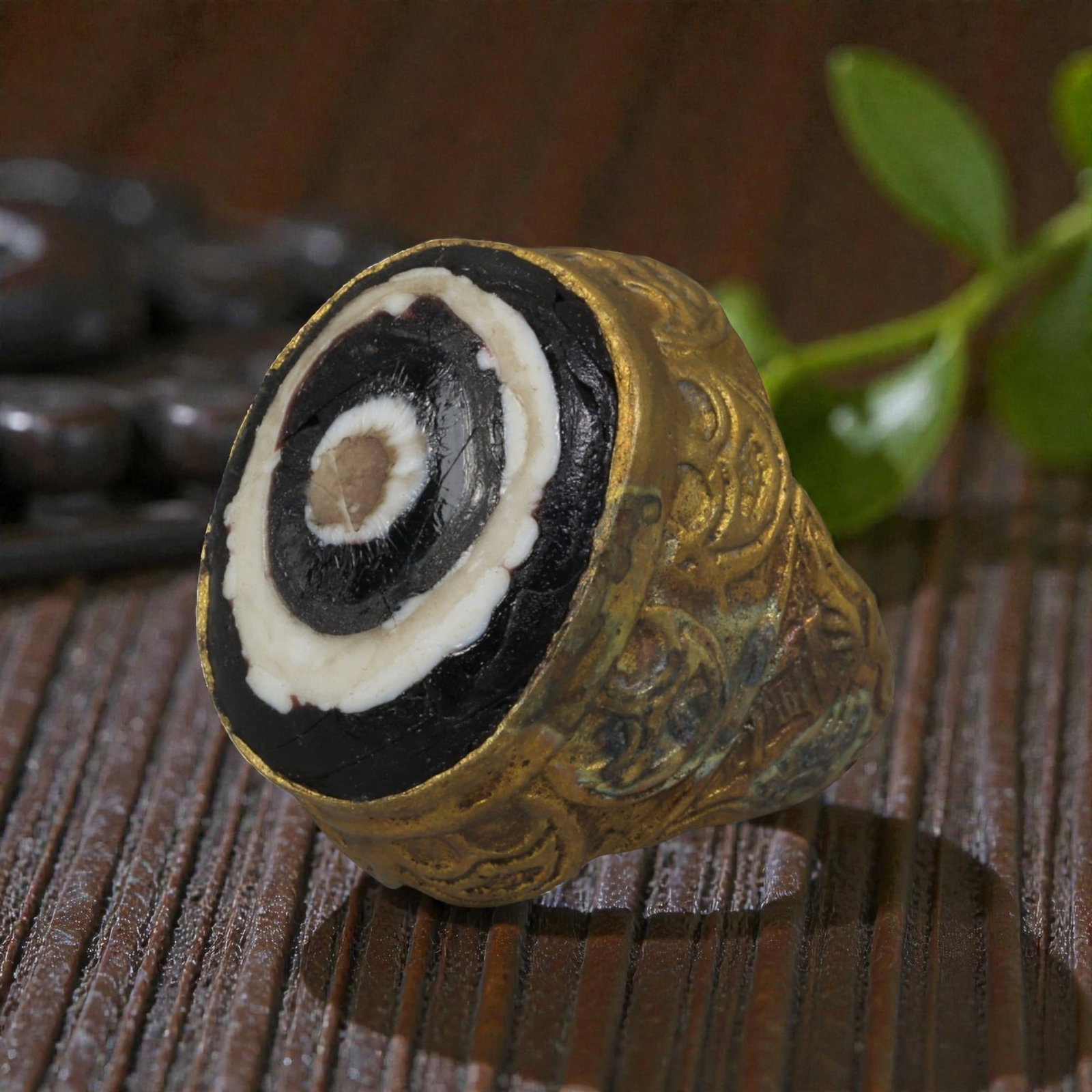 Antique Qajar Dynasty Gilt Evil Eye Ring, US Size 7.5, 28AJ: A gilt-metal ring of the Qajar period, US ring size 7.5, featuring a large domed evil-eye glass inlay with concentric black, white, and brown layers. The central eye motif is set within a richly decor