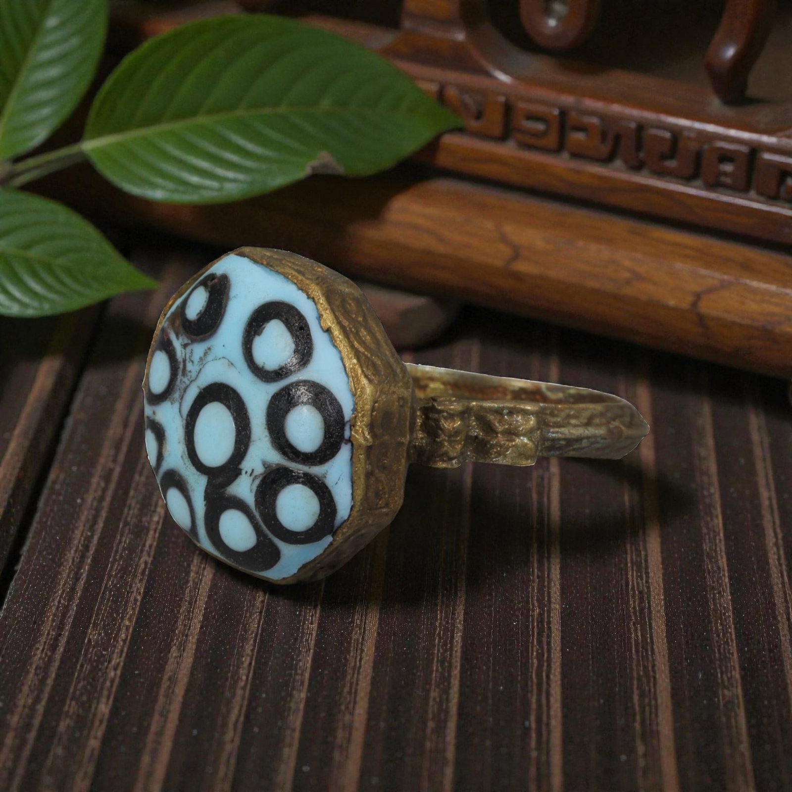 Antique Qajar Dynasty Gilt Evil Eye Ring, US Size 9.5, 18AJ: A gilt-metal ring of the Qajar period, US ring size 9.5, featuring a large domed evil-eye glass inlay with a vibrant light blue base adorned with multiple black-and-white concentric eye motifs. The oc