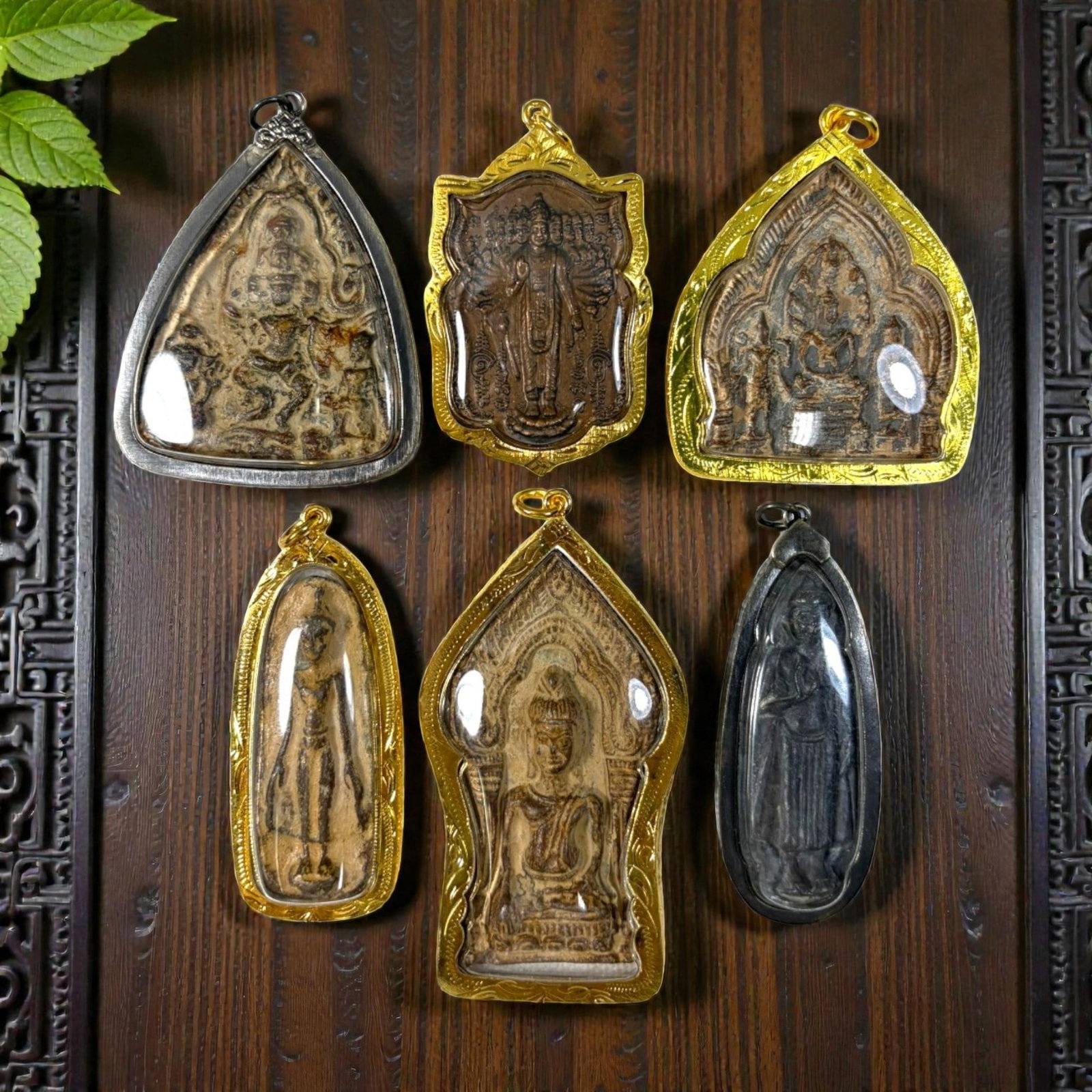 A Lot of 6 Vintage Thai Buddhist Amulets with Metal Cases, 39AA: Comprising six pendants ranging from 6 to 9 cm in height. Each amulet features aged devotional imagery, including seated, standing, and multi-armed Buddha forms, encased in protective metal frames-fou