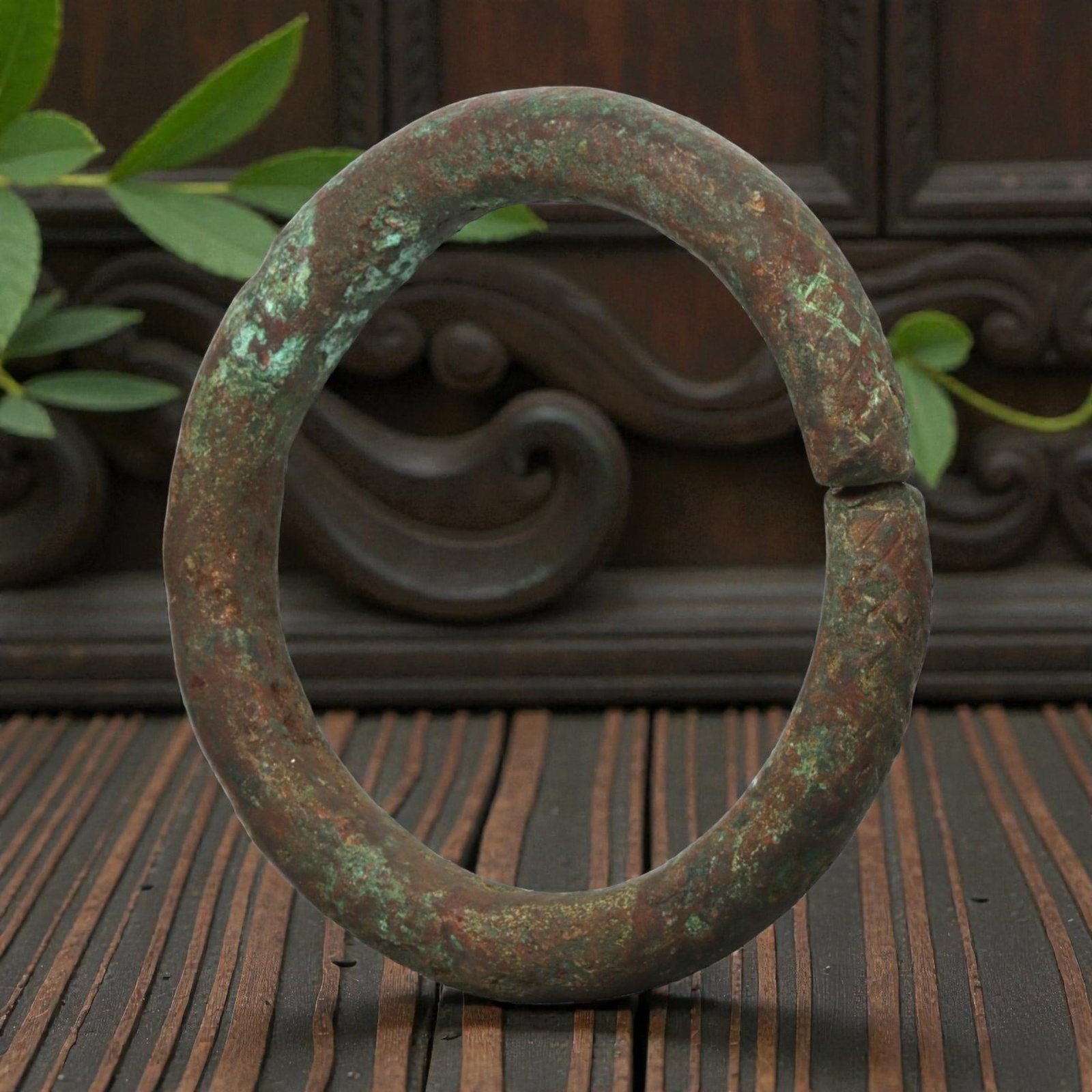 Ancient Bronze Bracelet - Roman Decorated Penannular Bangle, 83BN: A penannular bronze bracelet of ancient Roman origin, formed from a thick, rounded bronze band. The open terminals bear incised geometric motifs, providing subtle decorative detail characteristic of R