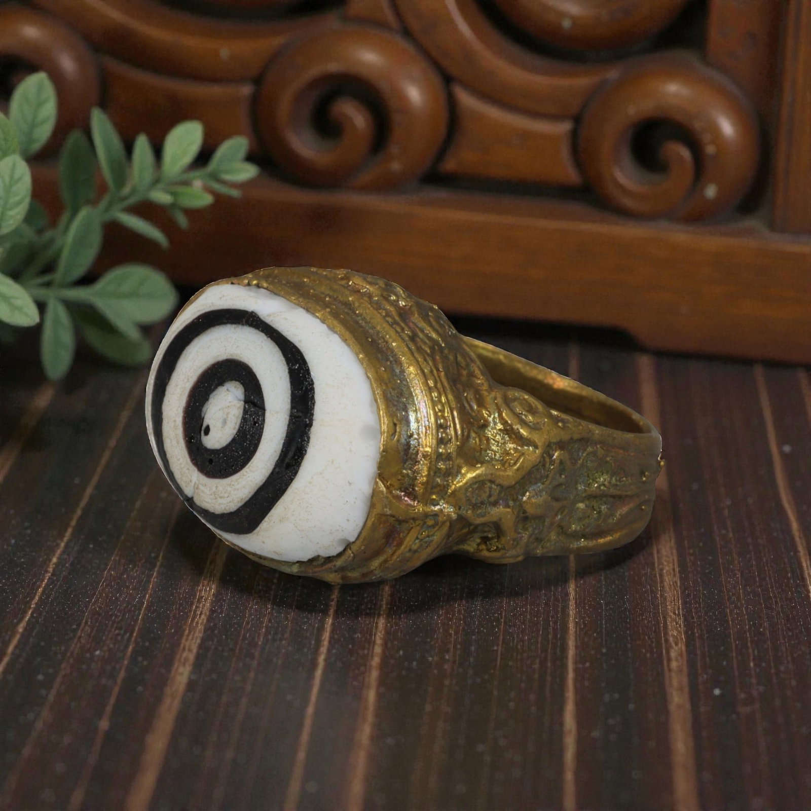 Antique Qajar Dynasty Gilt Evil Eye Ring, US Size 8, 23AJ: A gilt-metal ring of the Qajar period, US ring size 8, featuring a large domed evil-eye glass inlay with a bold concentric black-and-white design (the glass exhibits age-related cracks). The domed bez