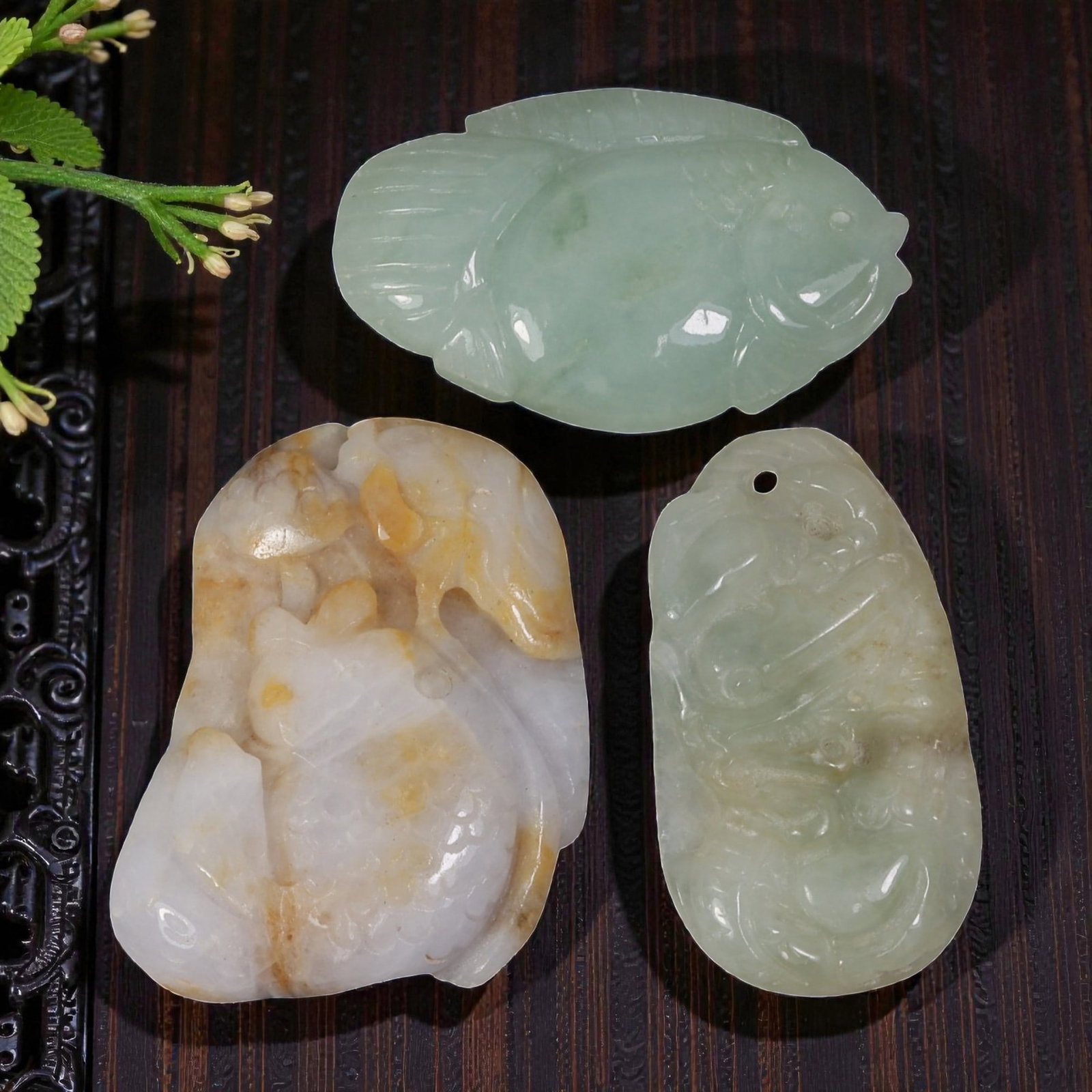 Lot of 3 Antique Oriental Chinese Jadeite Jade Fish Pendants, 41AG: Carved from jadeite jade with varied natural tones including pale green, light green with lavender, and yellowish-brown inclusions, the three pendants each depict fish motifs. The top pendant is a sim
