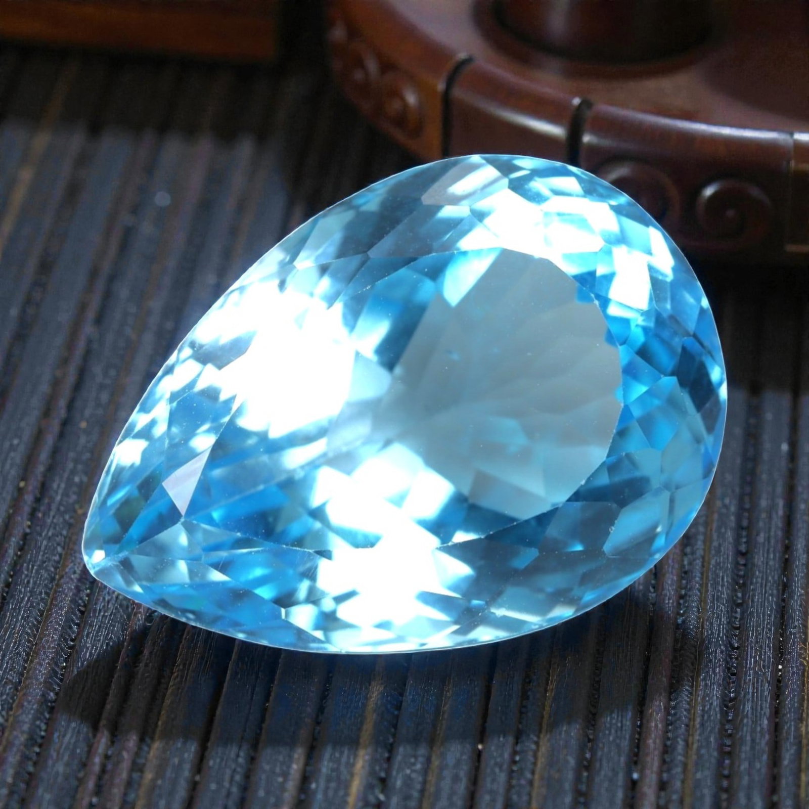 31.44 Carats Swiss Blue Topaz Pear - Natural Brazilian Stone, LZ104: This magnificent pear-cut Swiss blue topaz radiates with a vibrant, icy blue hue that evokes the clarity of alpine lakes and glacial skies. The gem is masterfully faceted, with precisely angled surfac