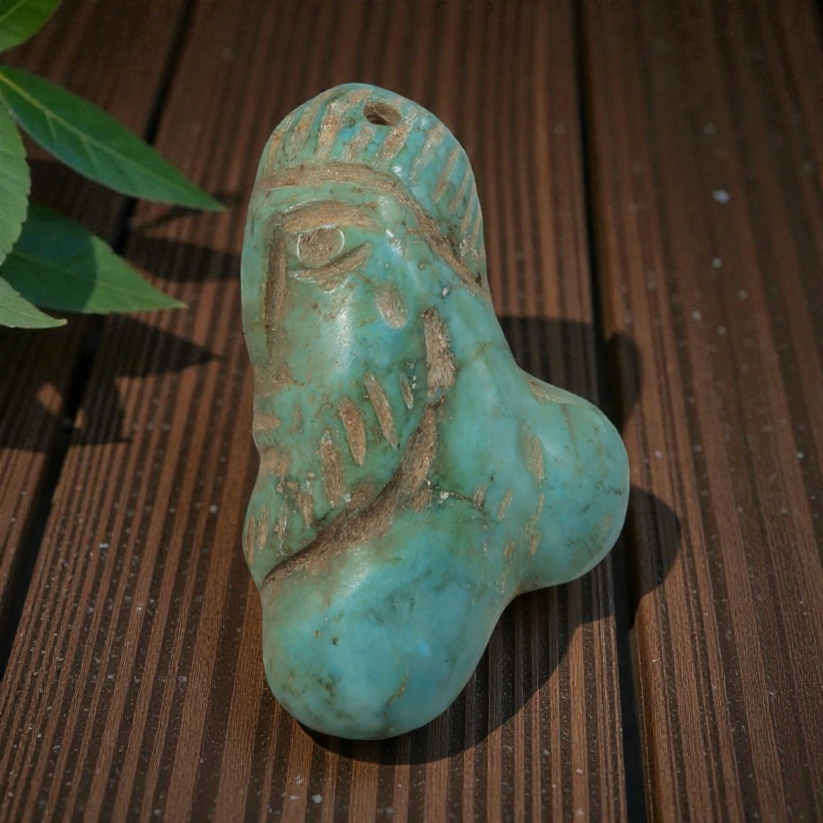 Antique Coptic Egyptian Style Turquoise Stone Bust Amulet, 4AP: Carved from turquoise stone with blue-green coloration and subtle tonal variations, the amulet depicts a stylized bust of a human figure. The figure features a single incised eye, simplified facial de