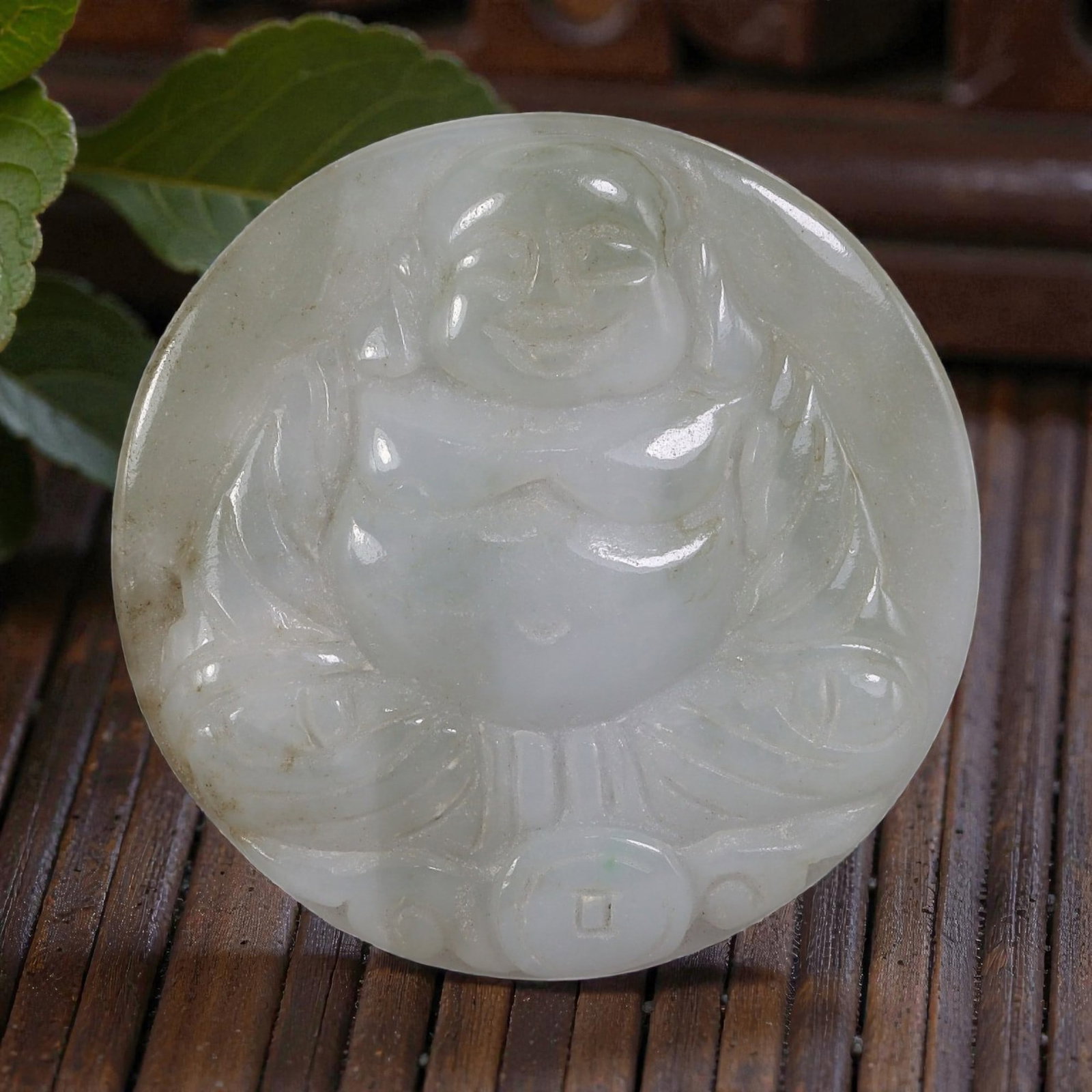 Old Chinese Jadeite Jade Budai Pendant, 11AP: Carved from jadeite jade with pale, translucent light green coloration and subtle natural inclusions, the pendant depicts Budai (the Laughing Buddha) in a seated pose. The figure features a rounded fa