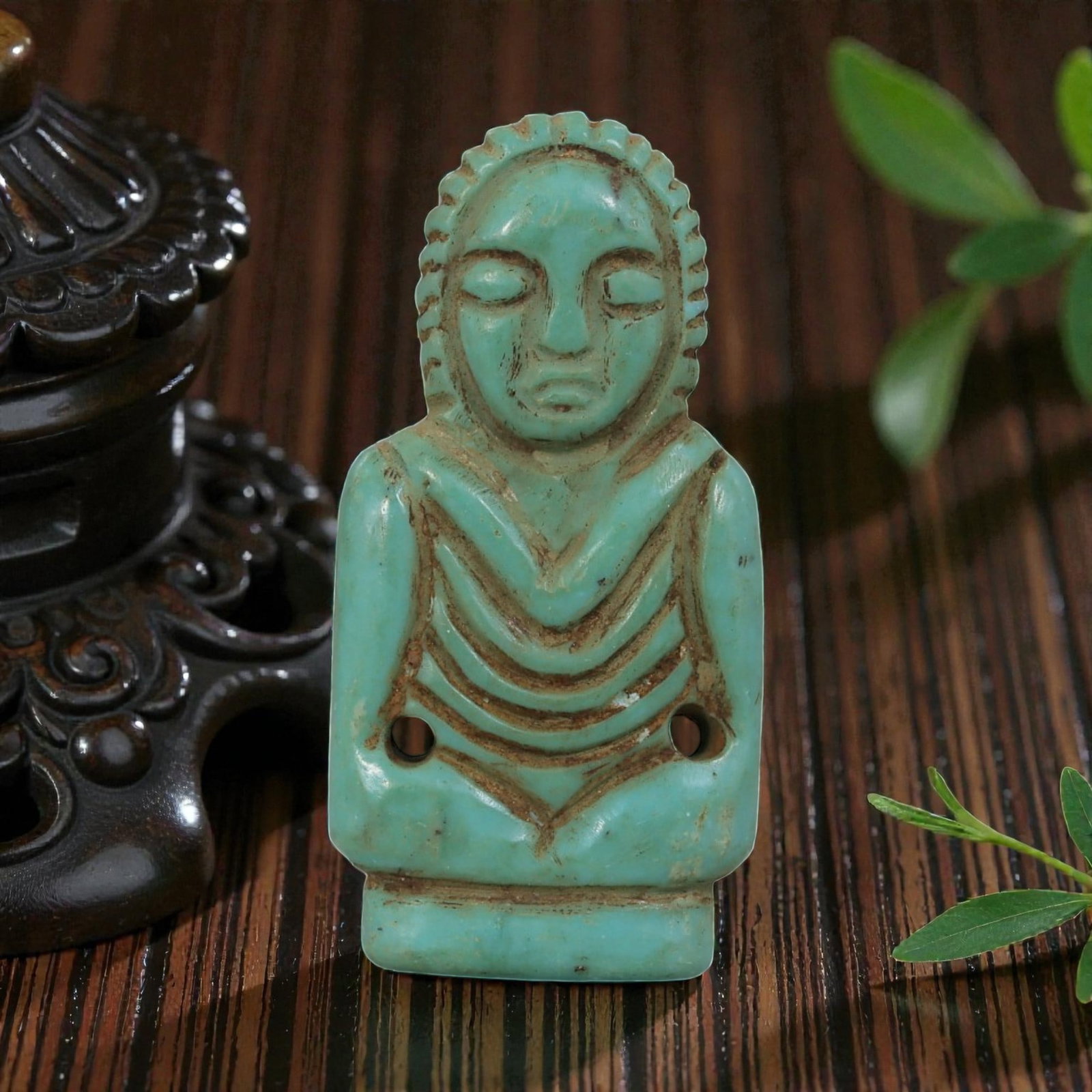Antique Coptic Egyptian Style Turquoise Stone Figural Amulet, 3AP: Carved from turquoise stone with rich blue-green coloration and subtle tonal variations, the amulet depicts a stylized bust of a human figure. The figure features a scalloped headdress, closed eyes, a
