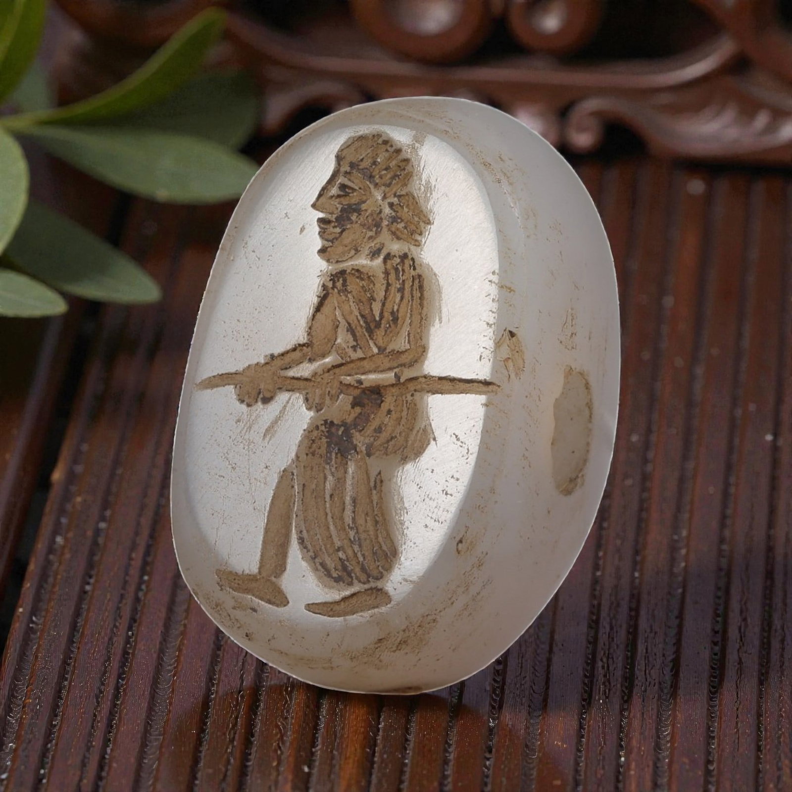 Ancient Sasanian Chalcedony Anthropomorphic Stamp Seal, 70YD: This ancient stamp seal is carved from translucent white chalcedony, with a domed, lenticular form and a central perforation for suspension. The flat face features a deeply engraved intaglio depicting